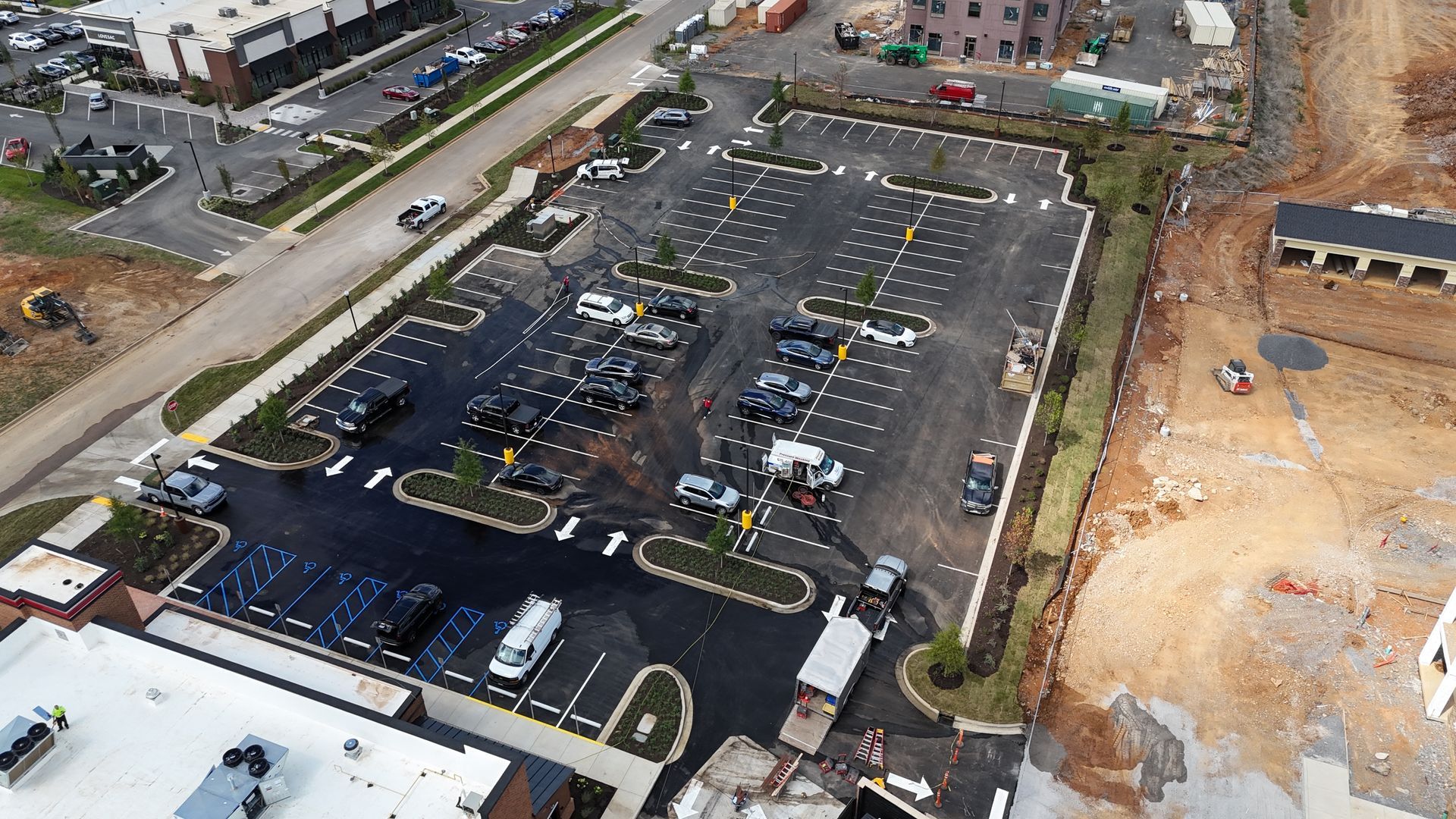 An aerial view of a parking lot with lots of cars parked in it.
