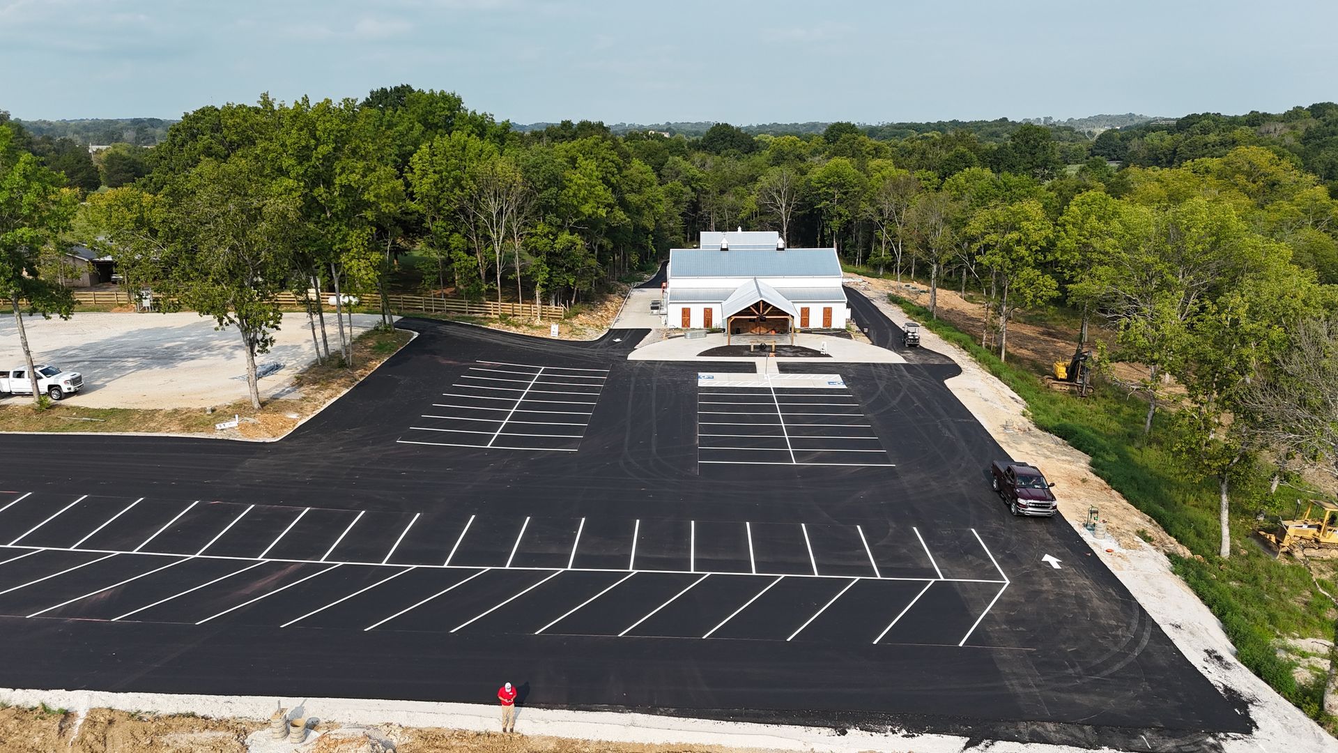 An aerial view of a parking lot with a building in the background.
