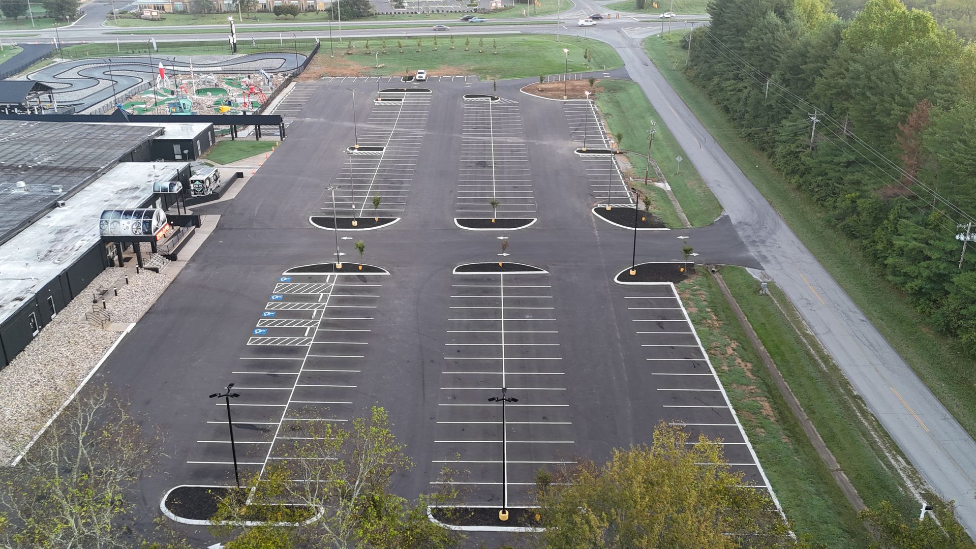 An aerial view of a parking lot with a building in the background