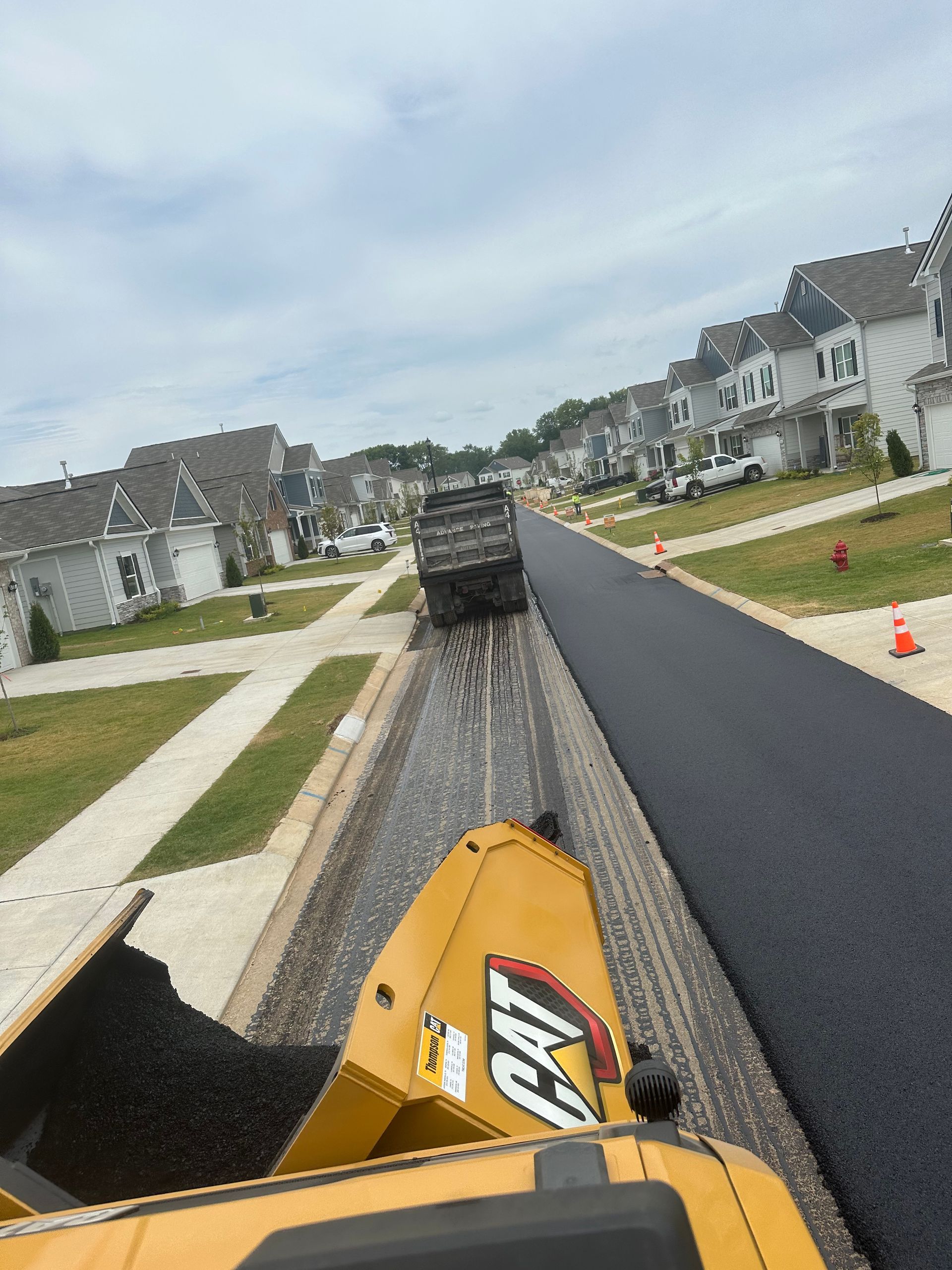 A yellow cat truck is driving down a road