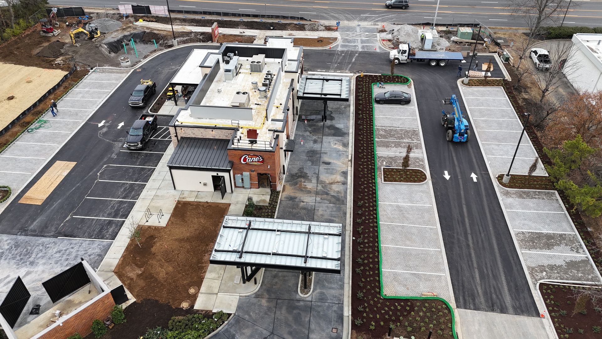 An aerial view of a parking lot with a building in the background