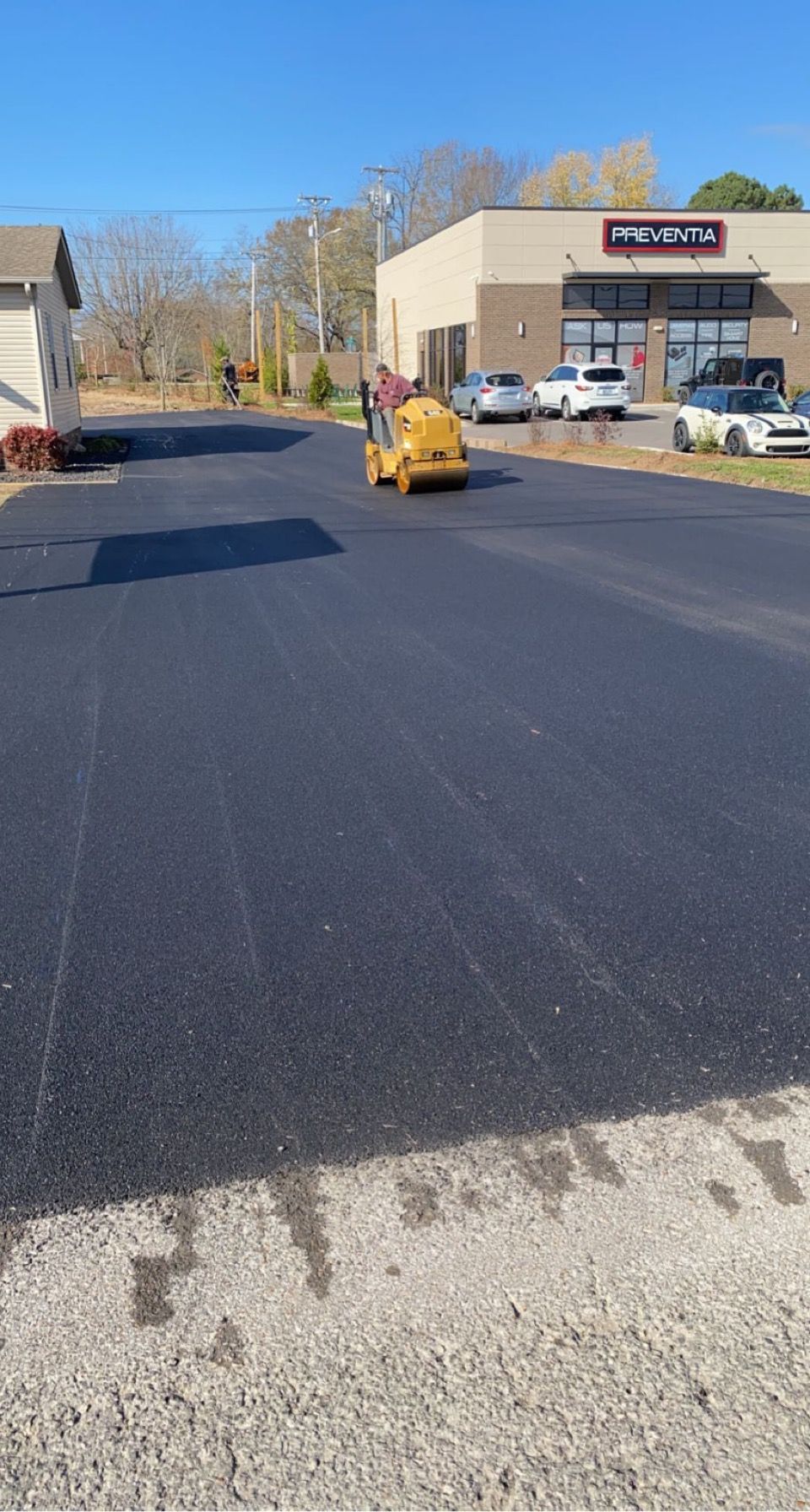 a yellow roller is rolling asphalt on a road