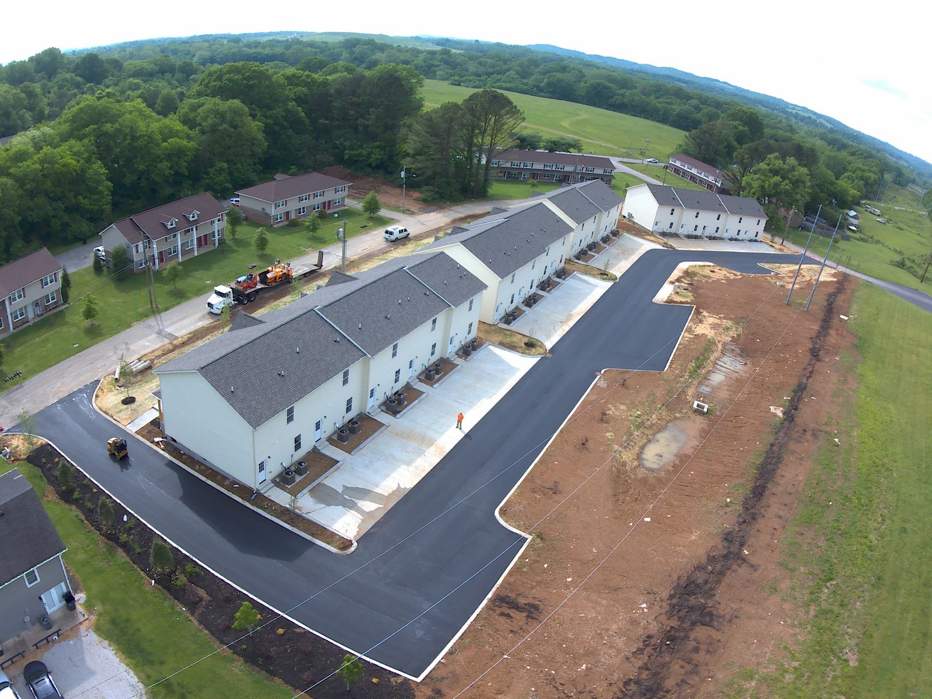 an aerial view of a row of houses with asphalt road