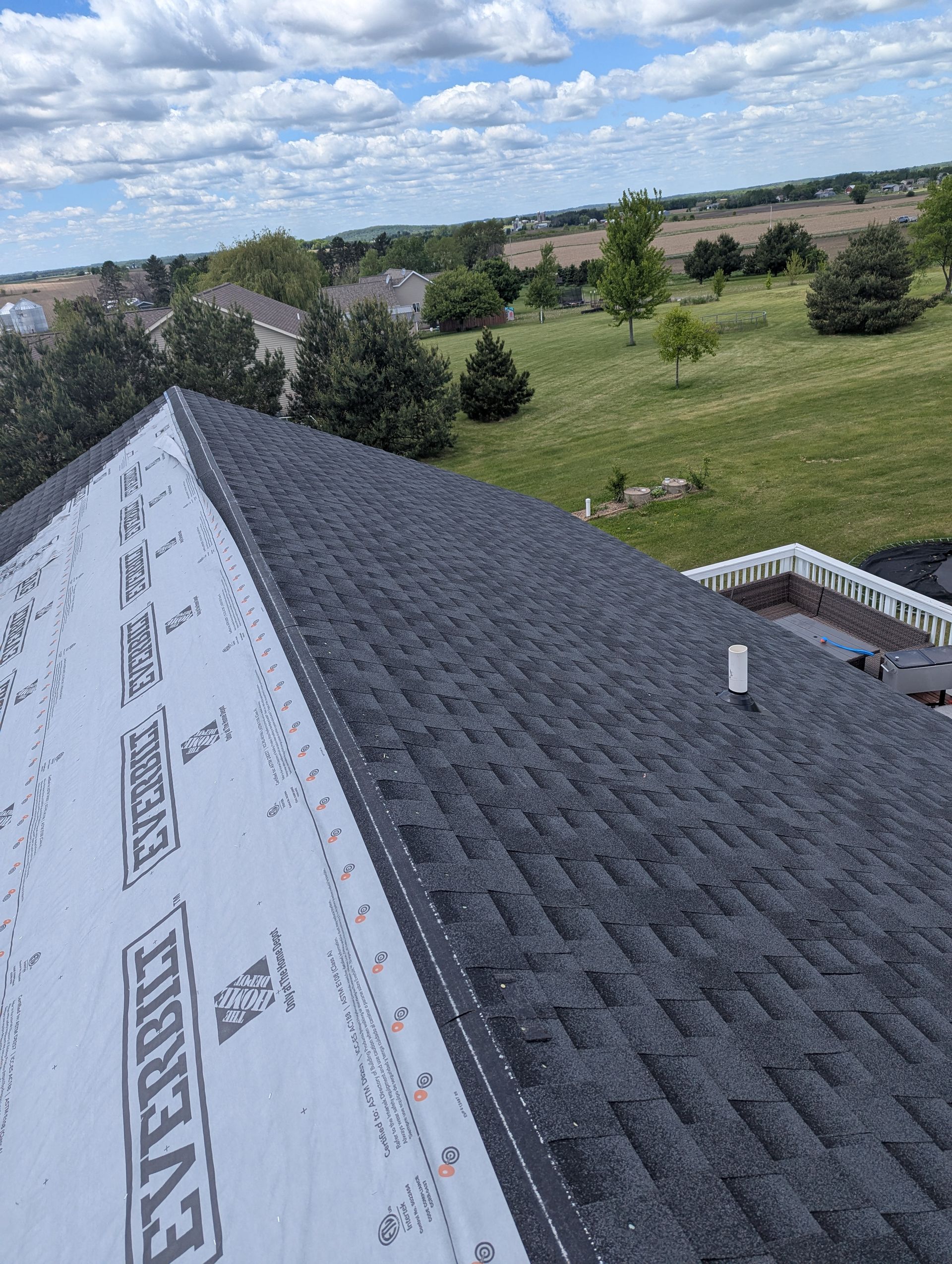 An aerial view of a roof with a lot of trees in the background.