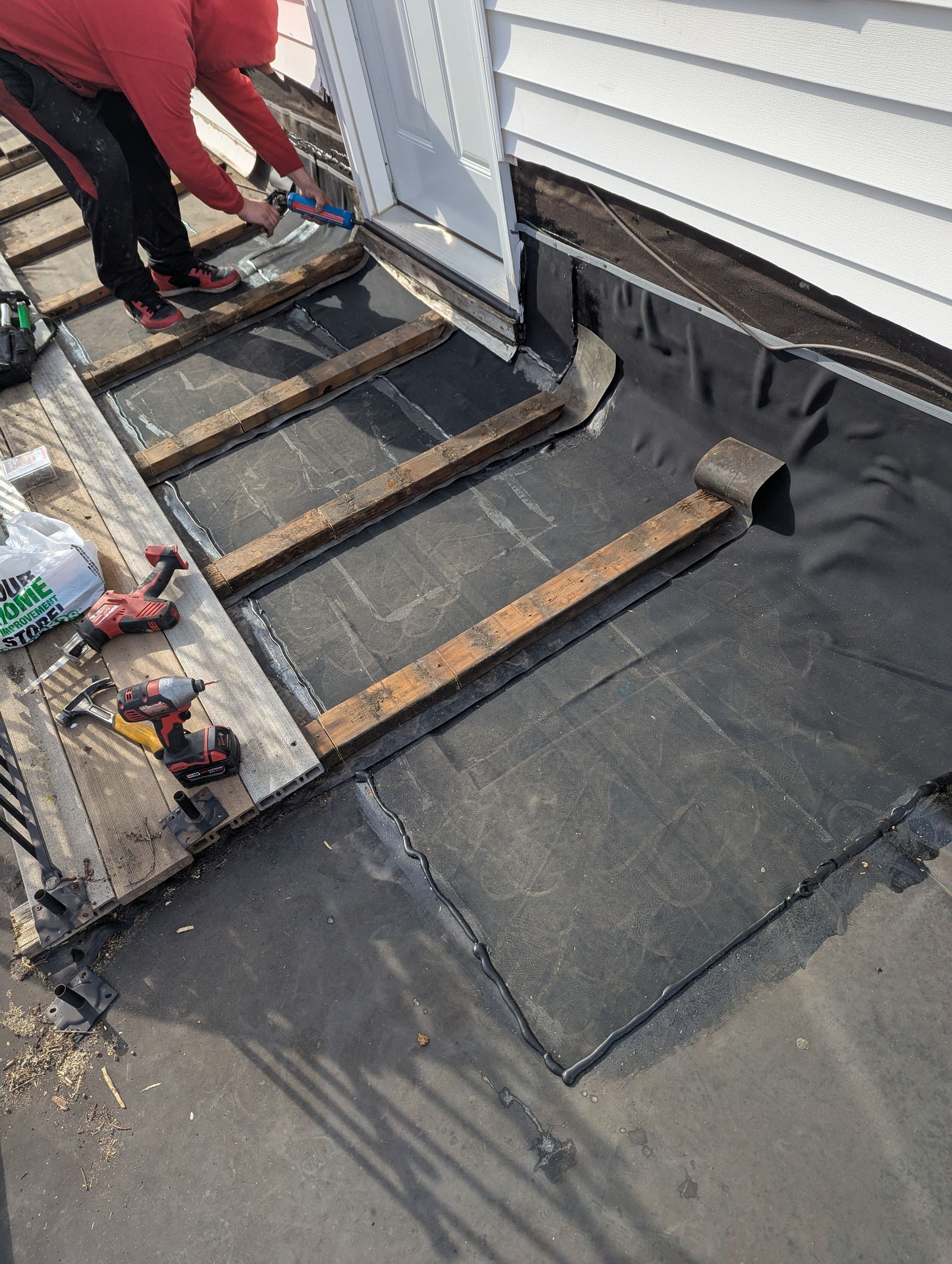 A man is working on the roof of a house.