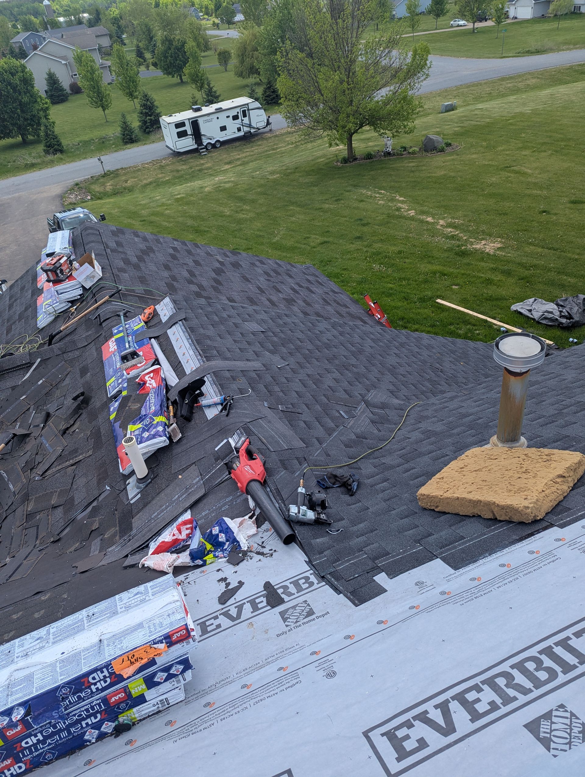 An aerial view of a roof under construction with a lot of tools on it.GA