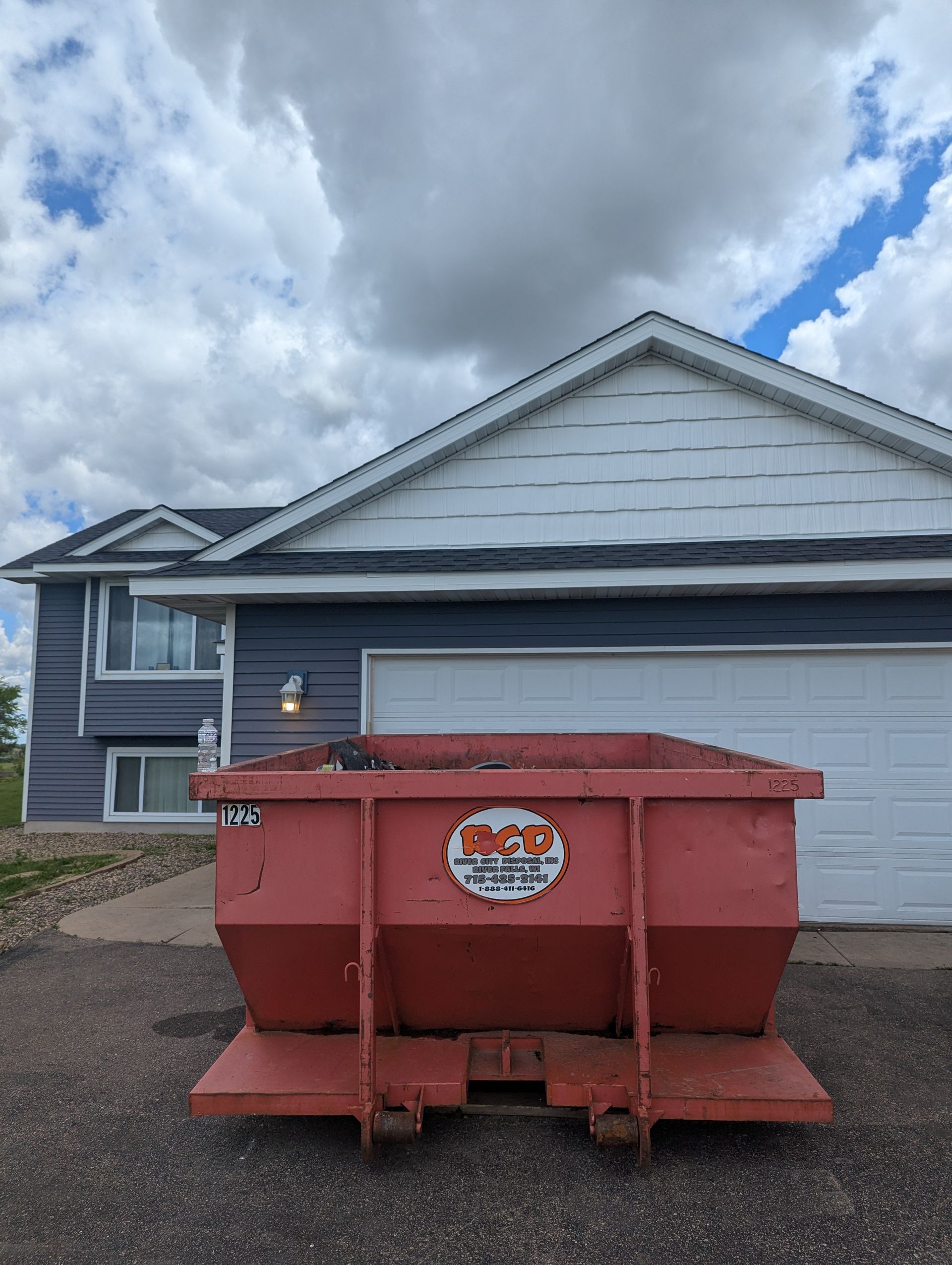 A red dumpster in front of the house.