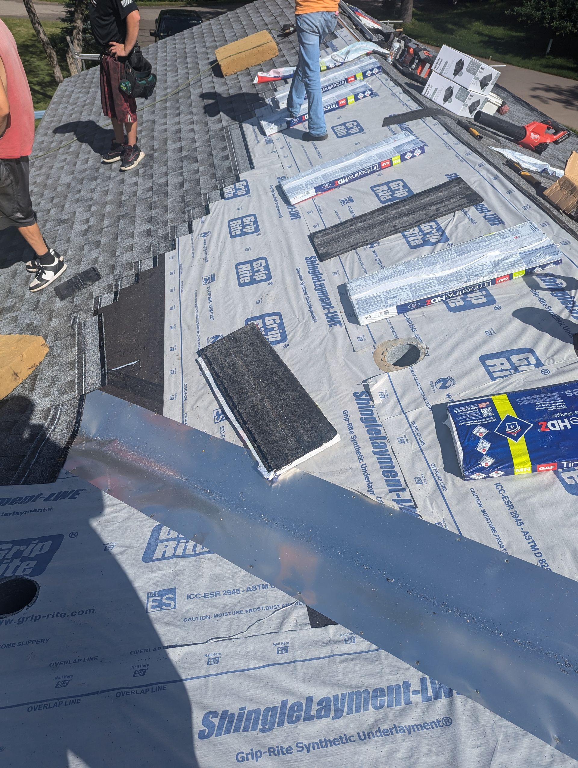 Workers installing roof materials.