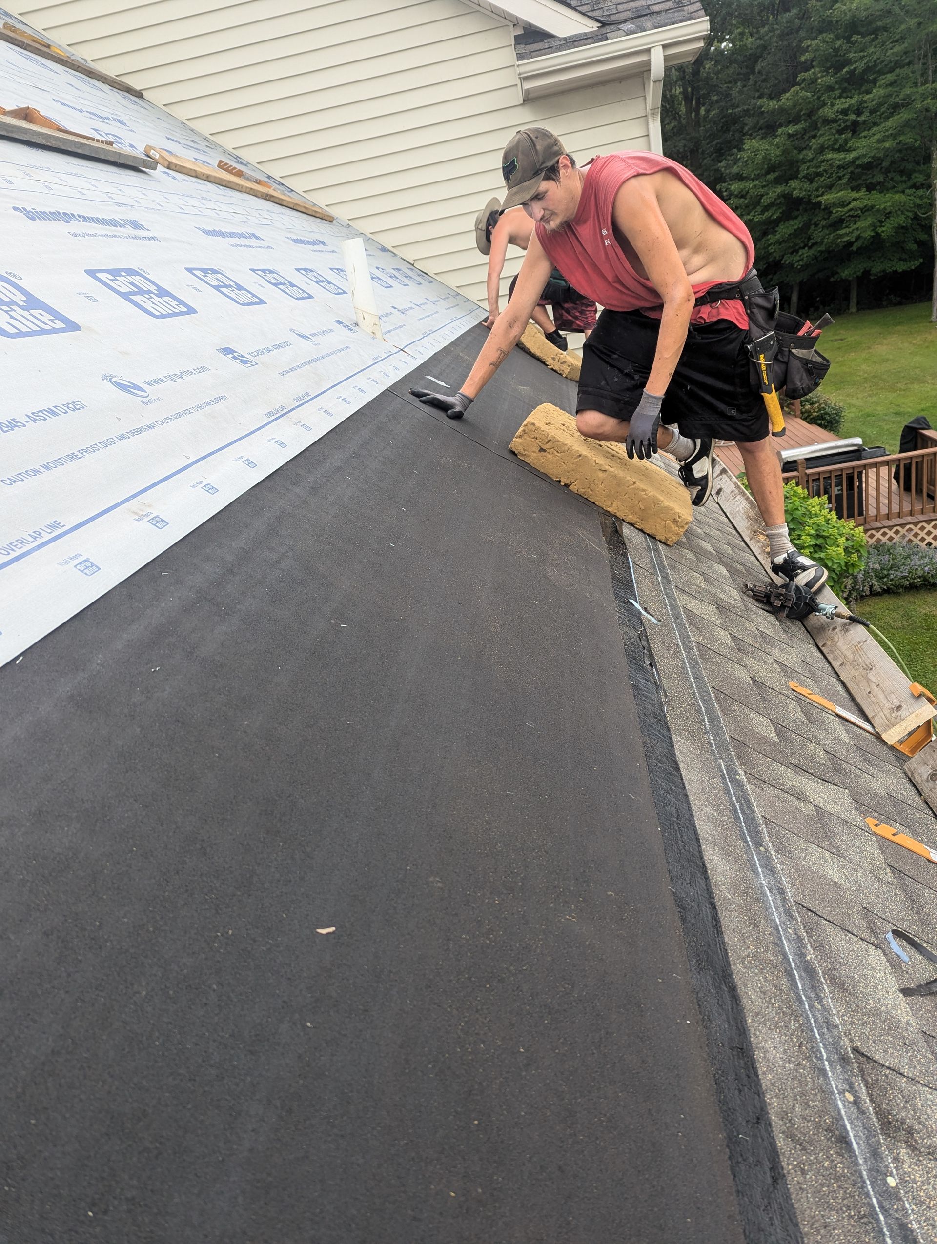 A man is working on the roof of a house.