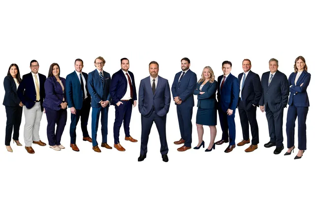 Group of professionals in navy business attire standing together on a white background