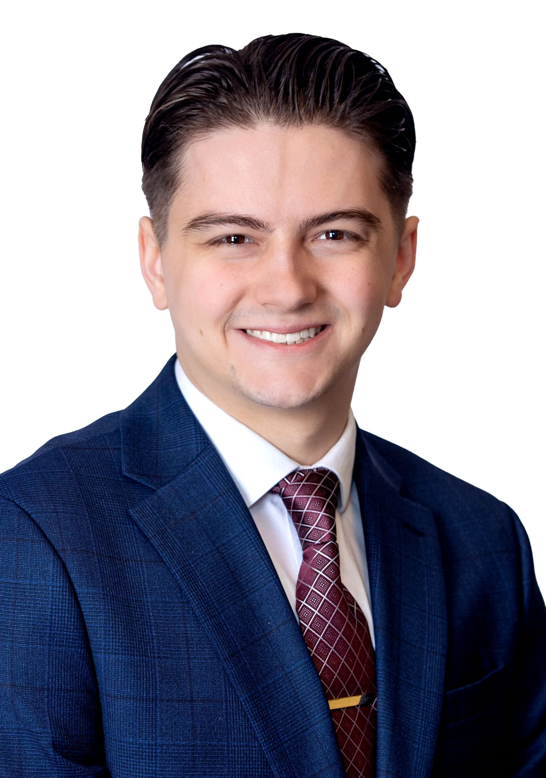 Man in blue suit, black tie, smiling. Studio headshot.