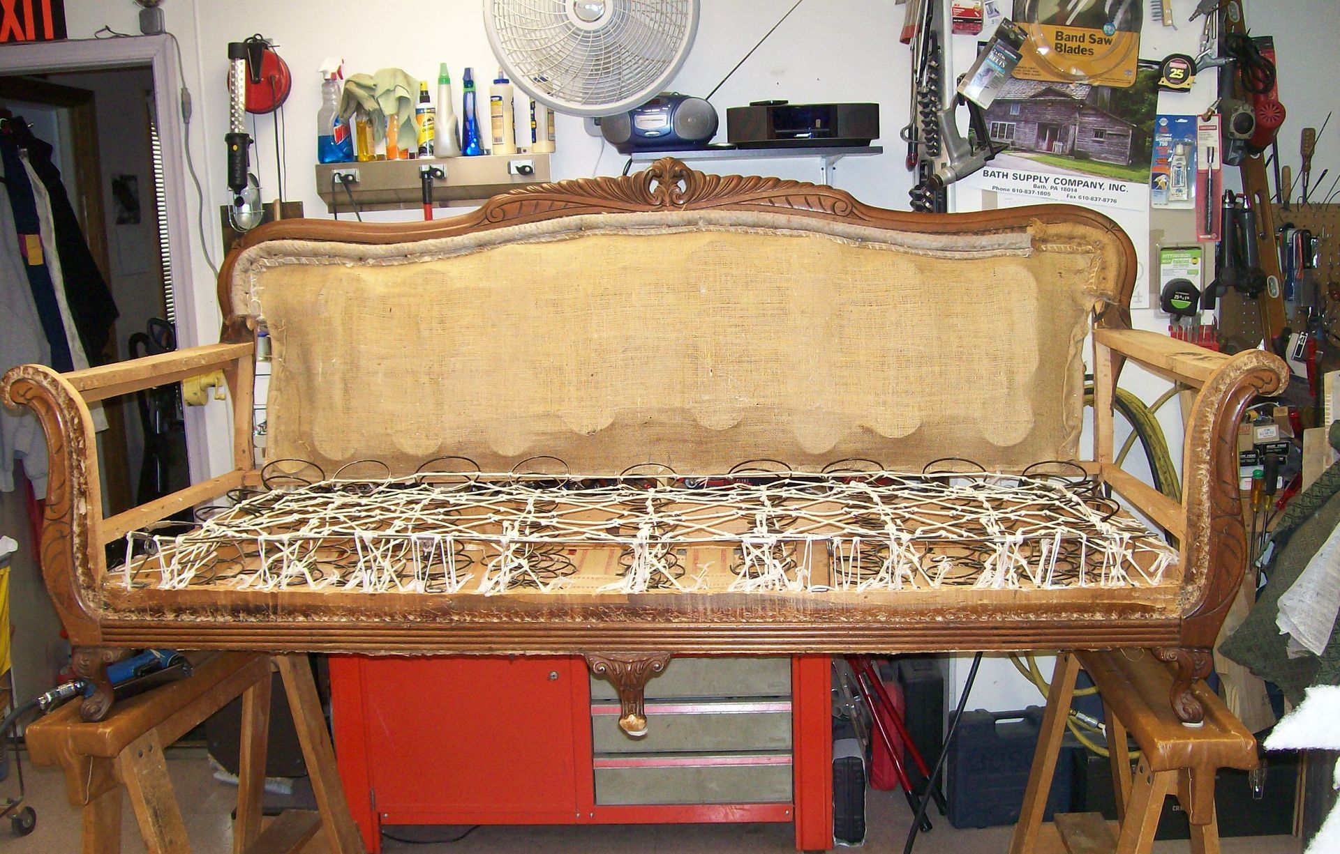 A couch is sitting in a room with a fan on the wall