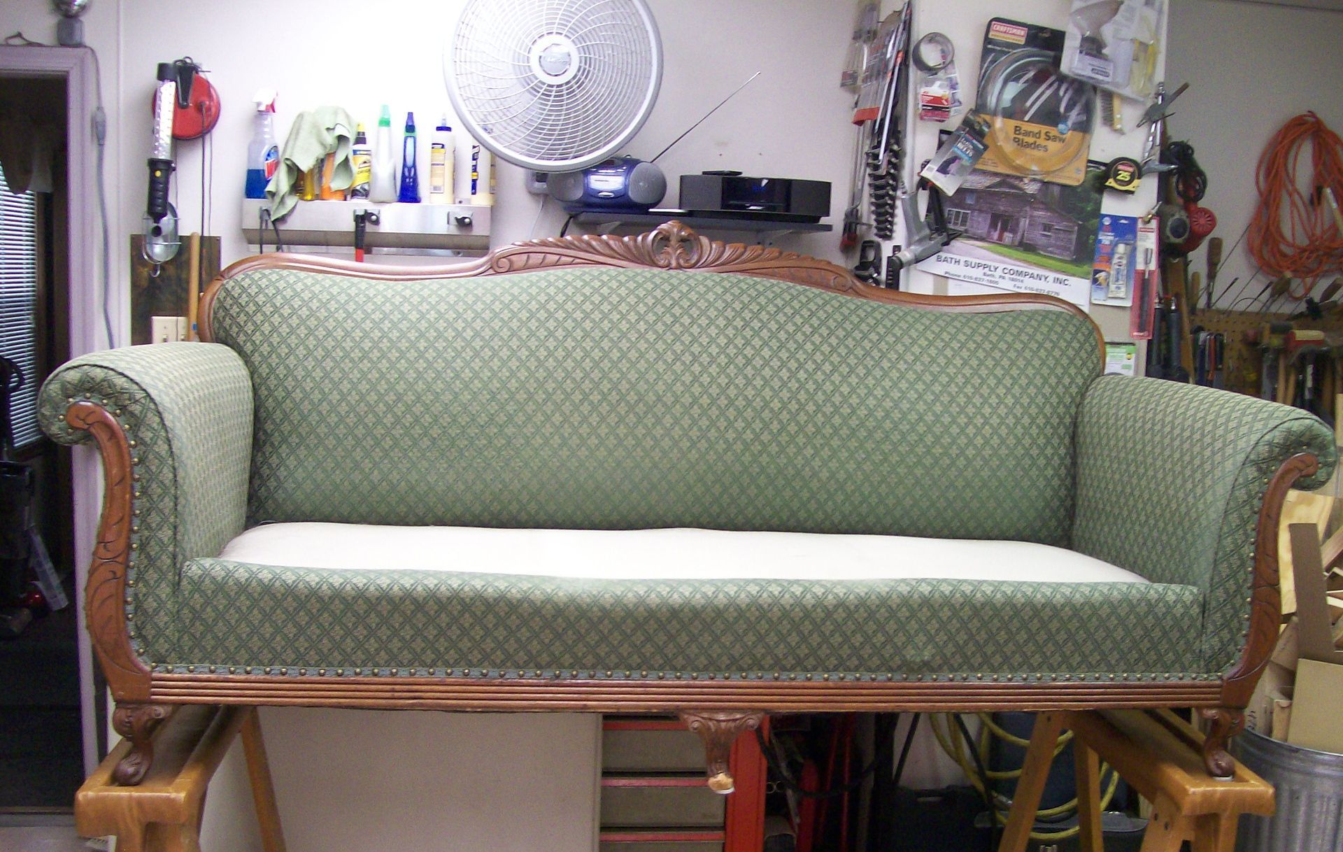 A green couch is sitting on a wooden table in a room