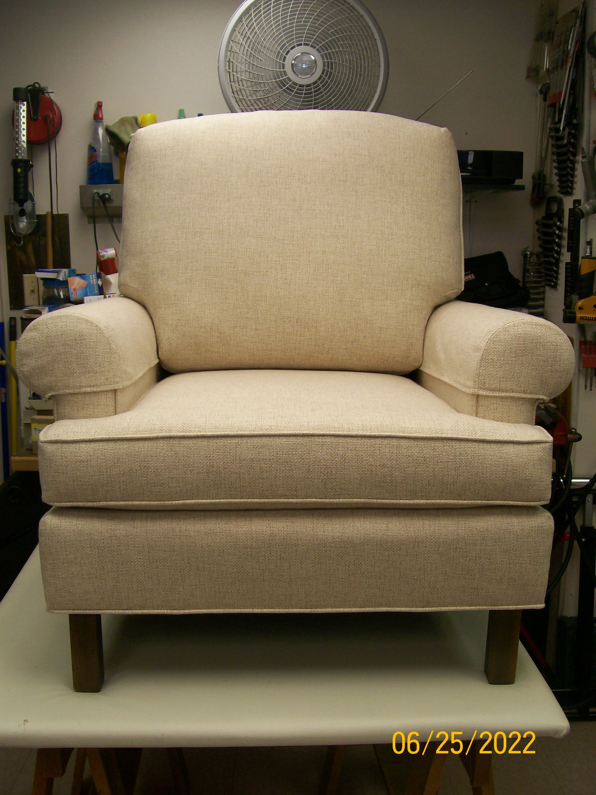 A chair is sitting on a table with a fan in the background