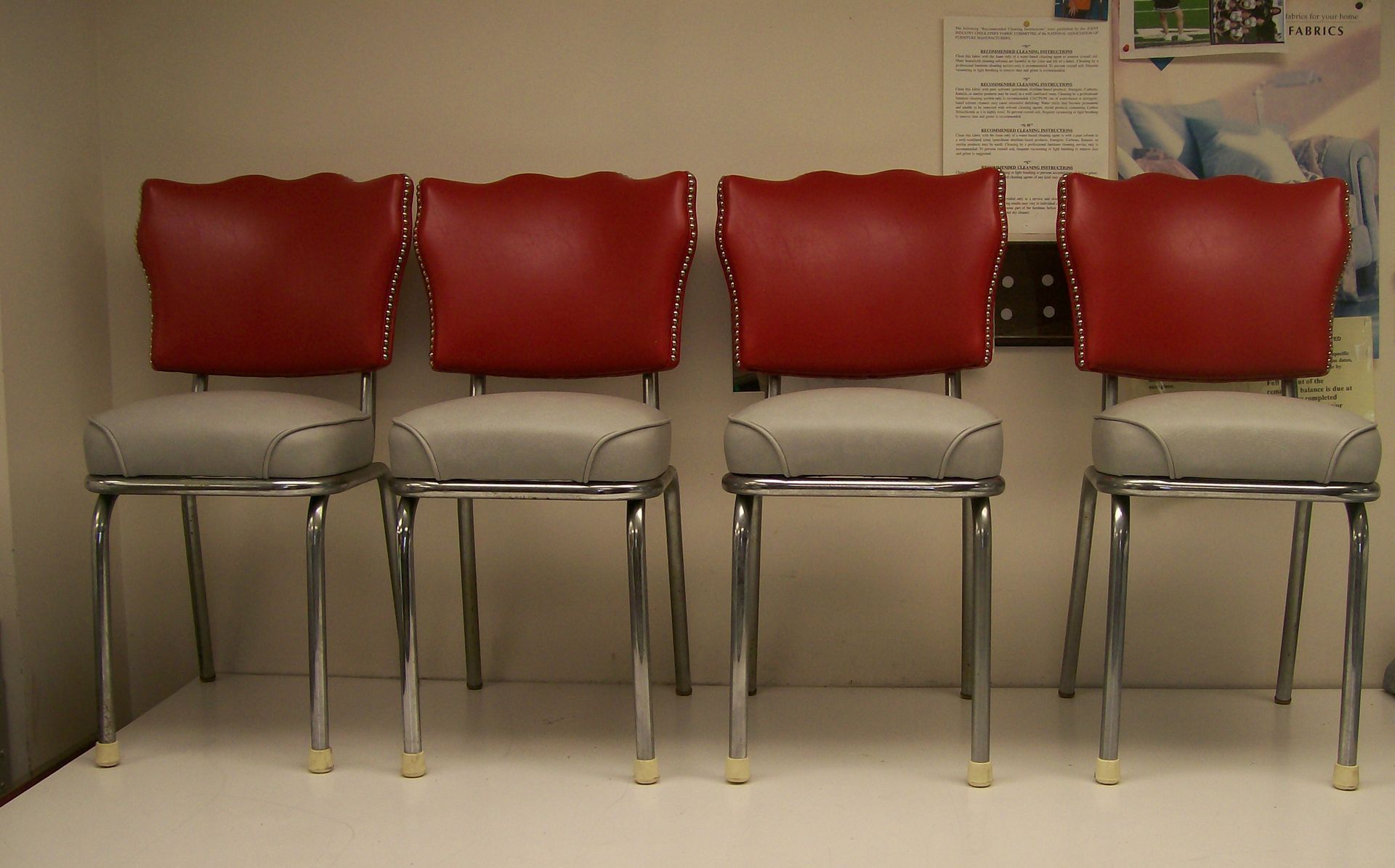 Four red and white chairs are lined up in a row