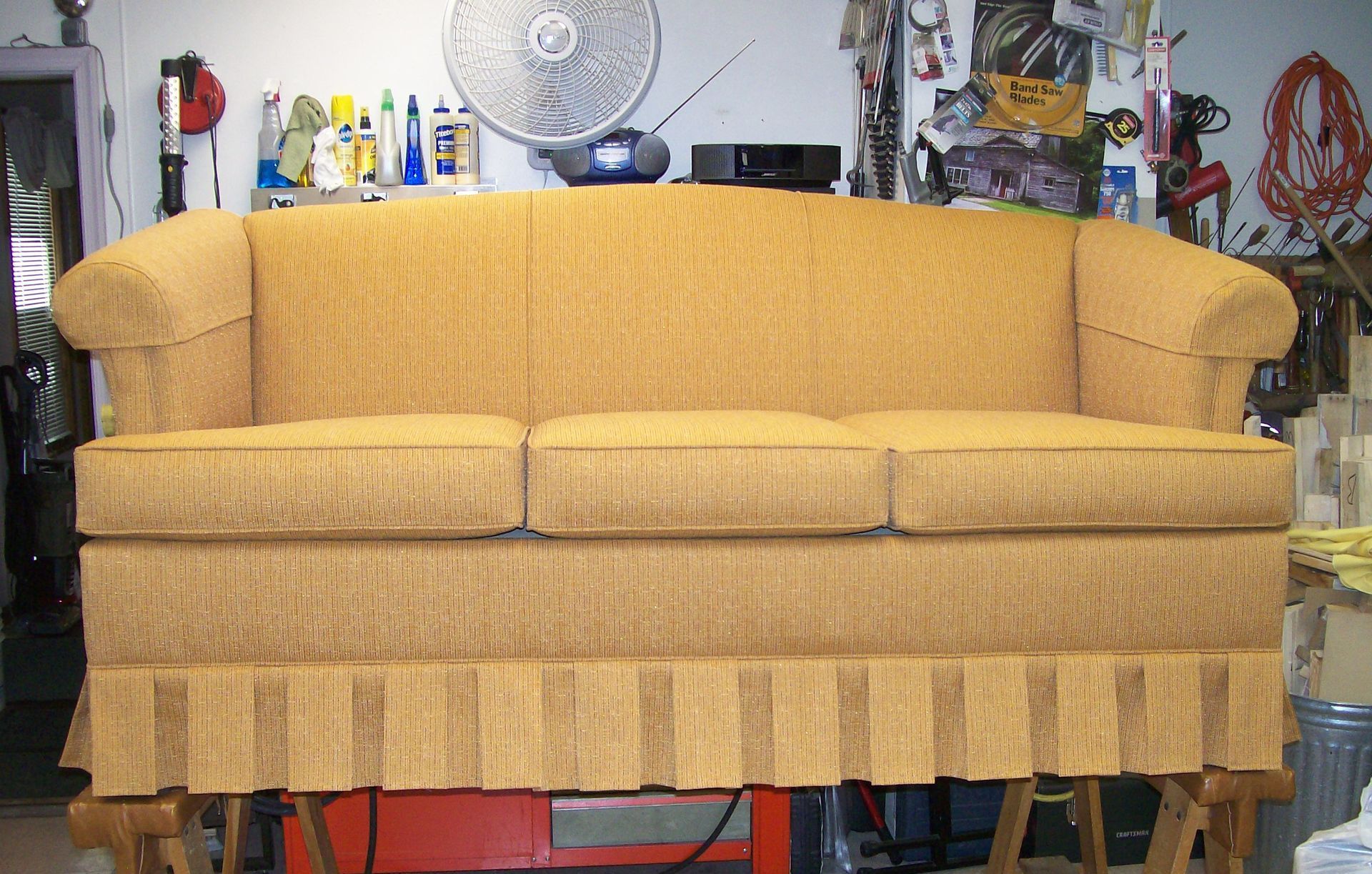 A yellow couch is sitting on a wooden table
