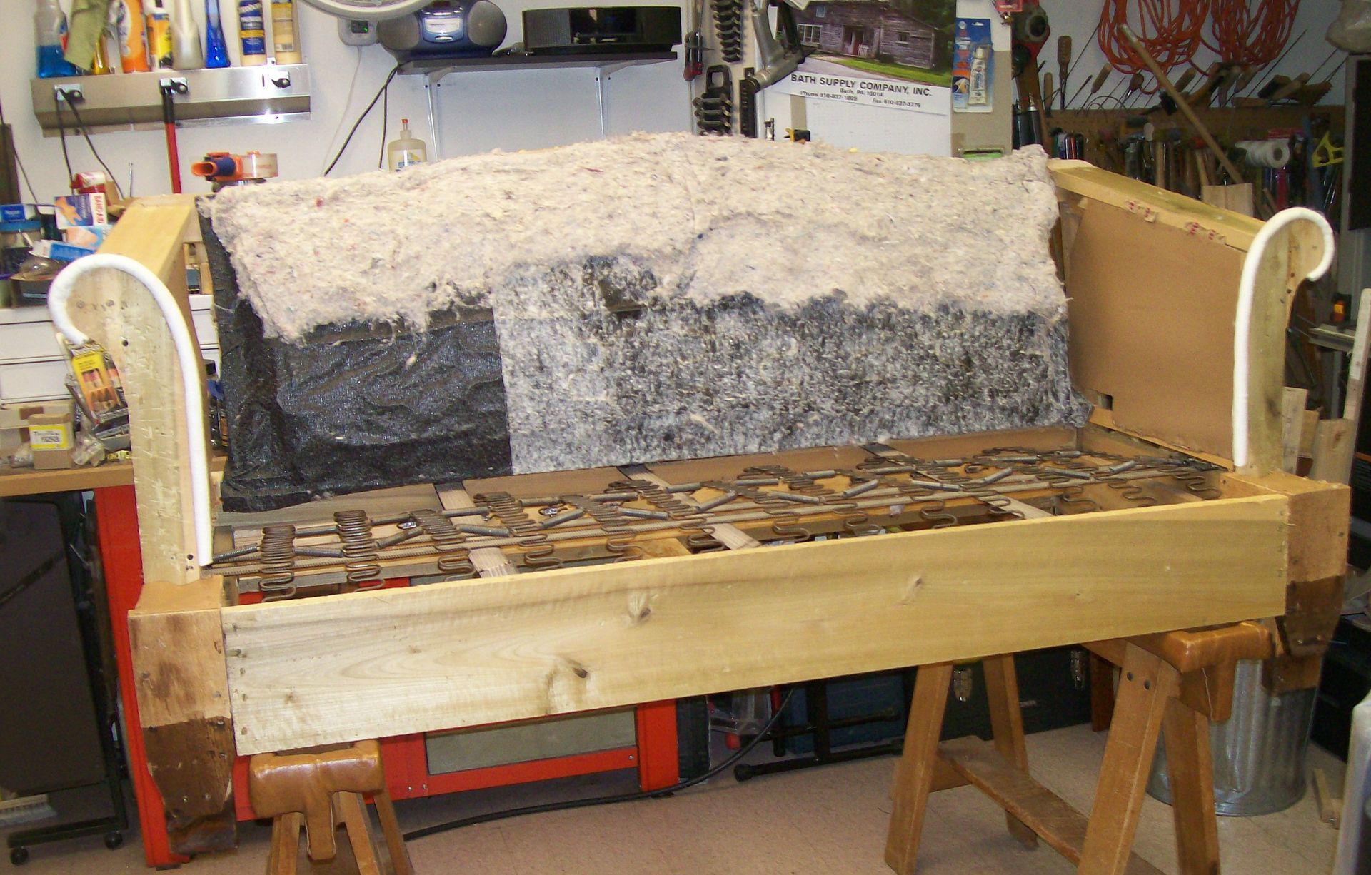 A wooden couch is being built in a workshop