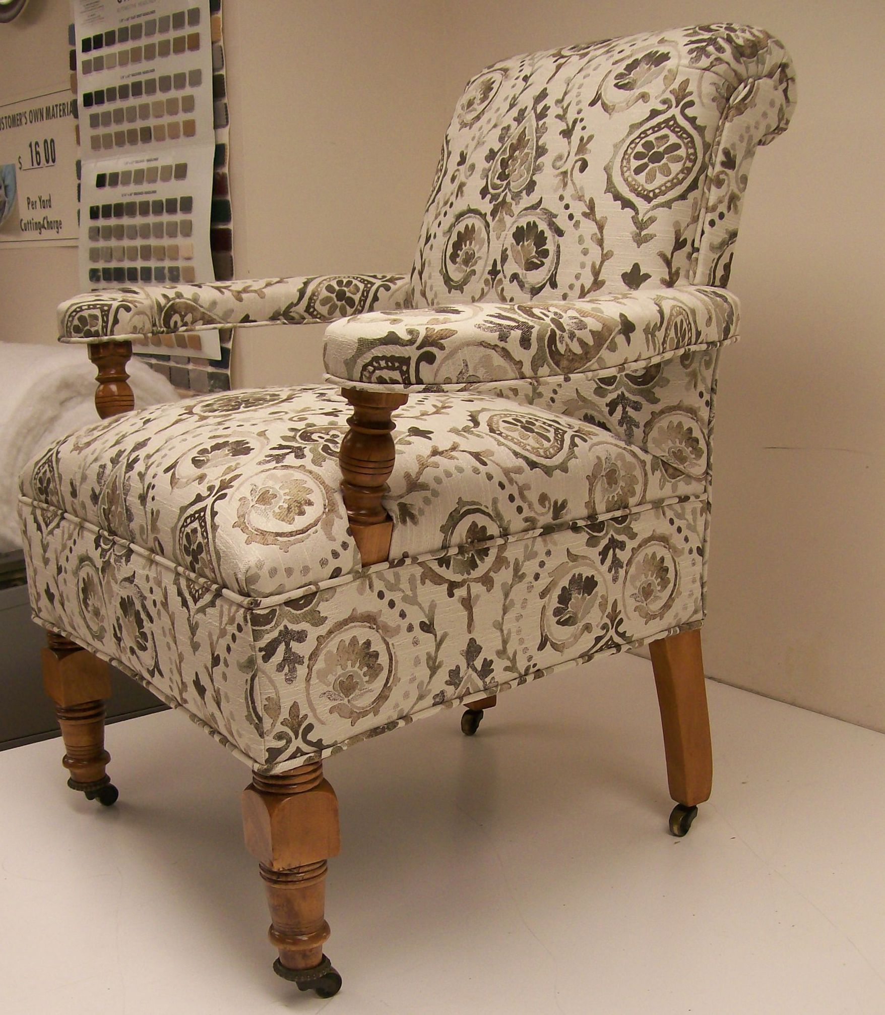A chair with a floral pattern and wooden legs