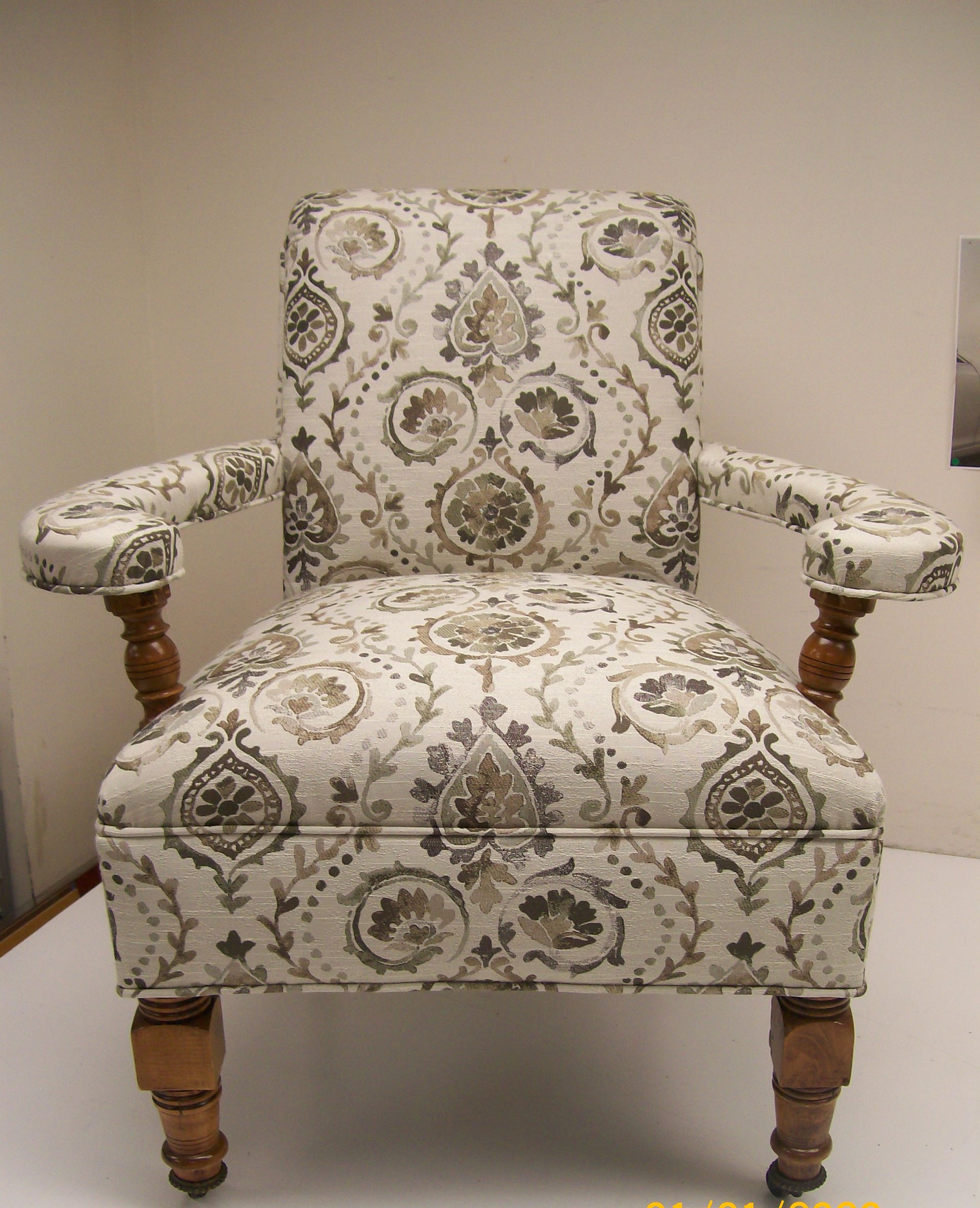 A chair with a floral pattern on it sits on a white surface