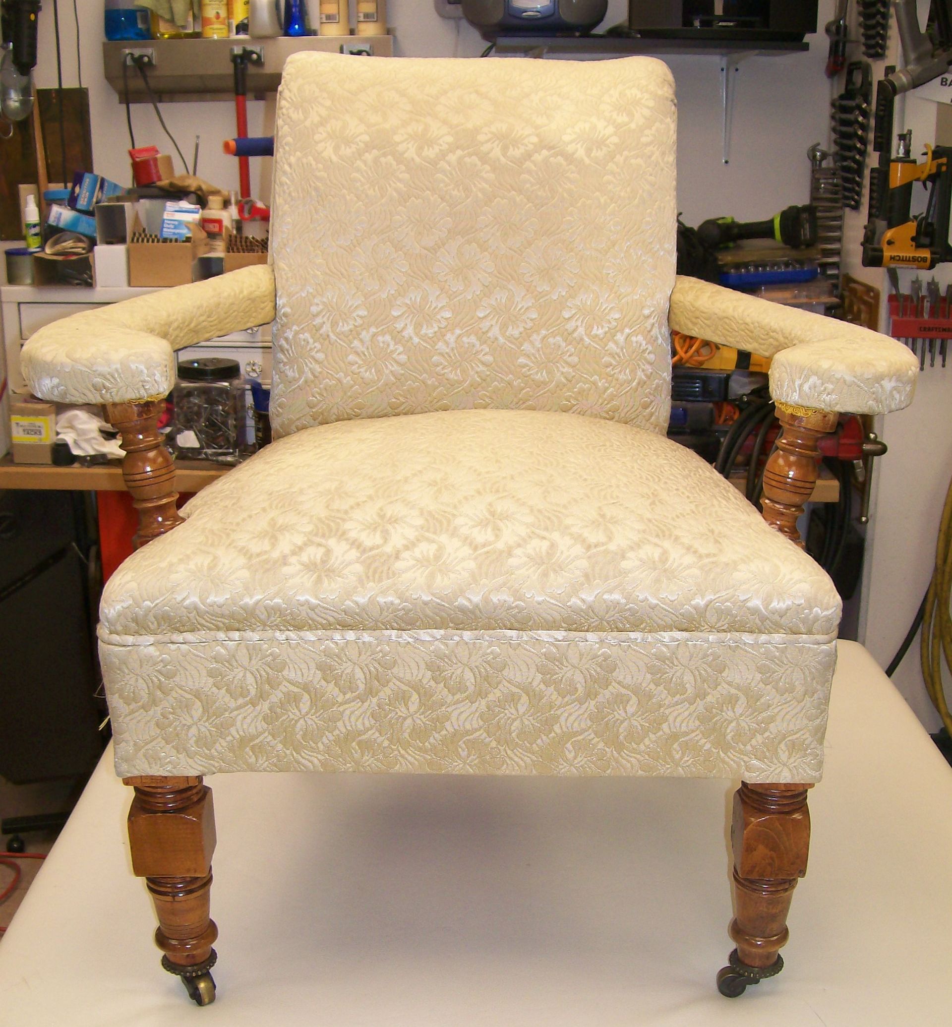 A white chair with wooden legs is sitting on a table