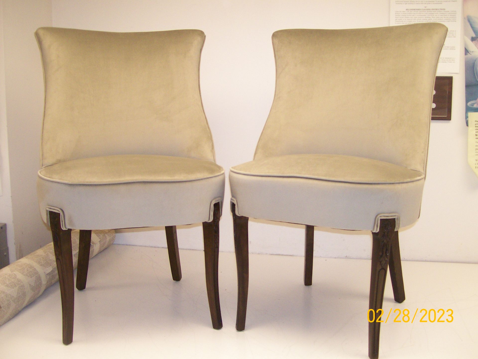 Two chairs are sitting next to each other on a white surface