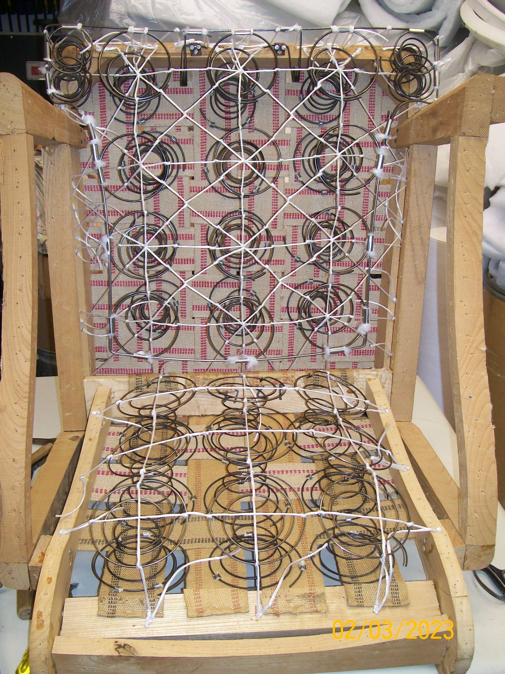 A wooden chair frame with a bunch of springs attached to it