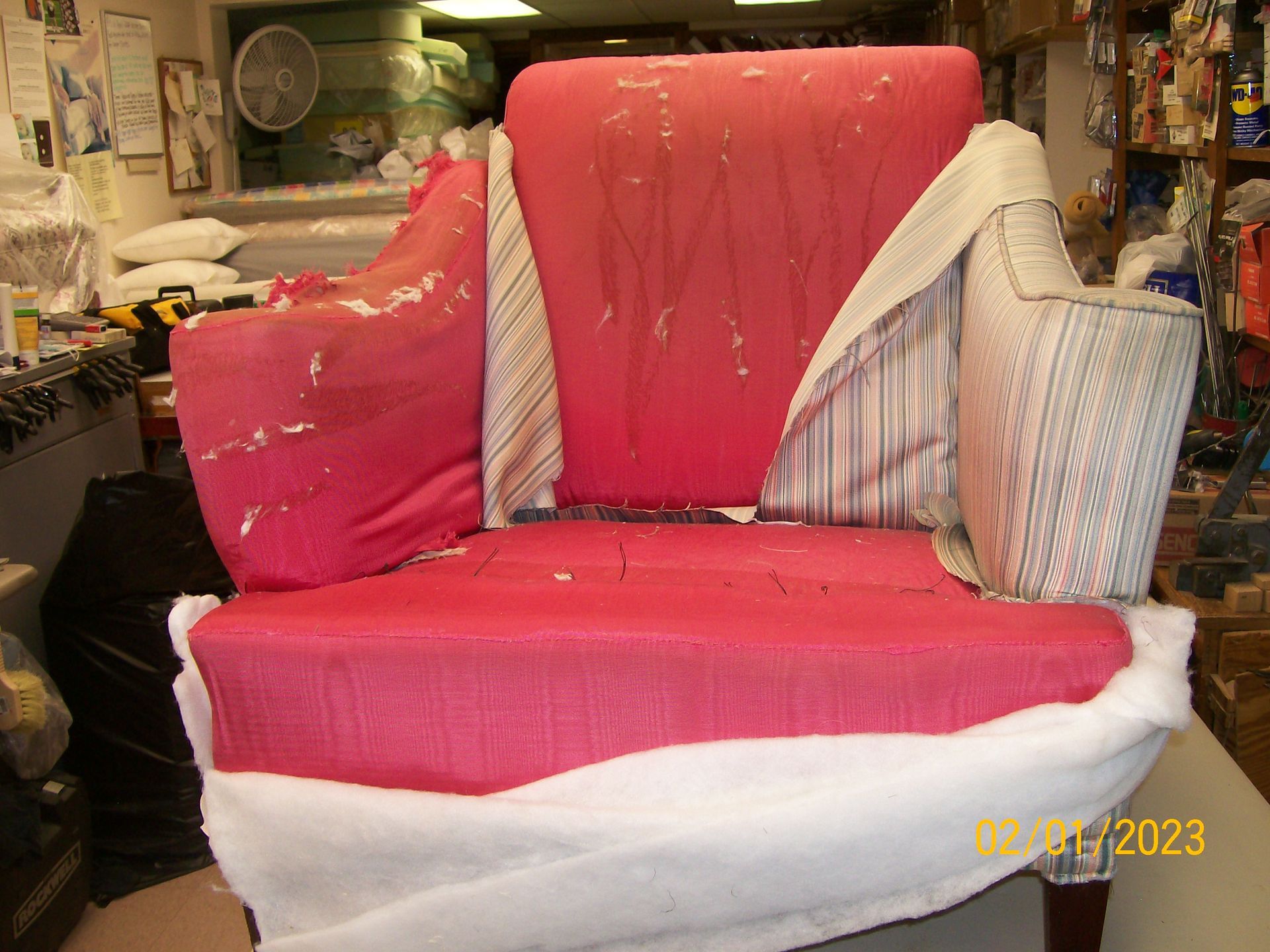 A pink chair is being reupholstered in a store