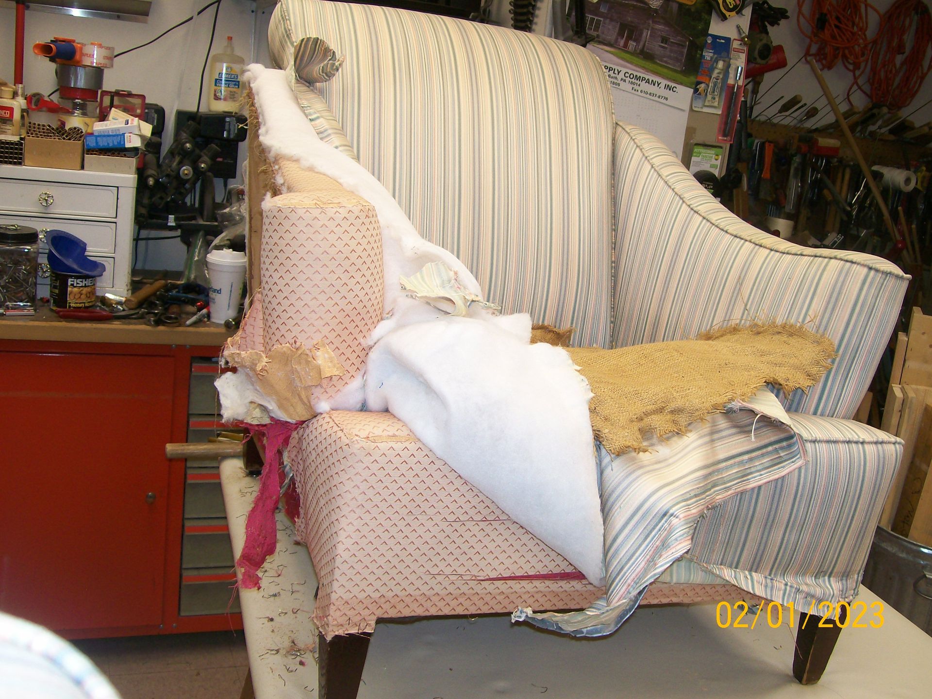 A chair is being remodeled in a room with a red cabinet