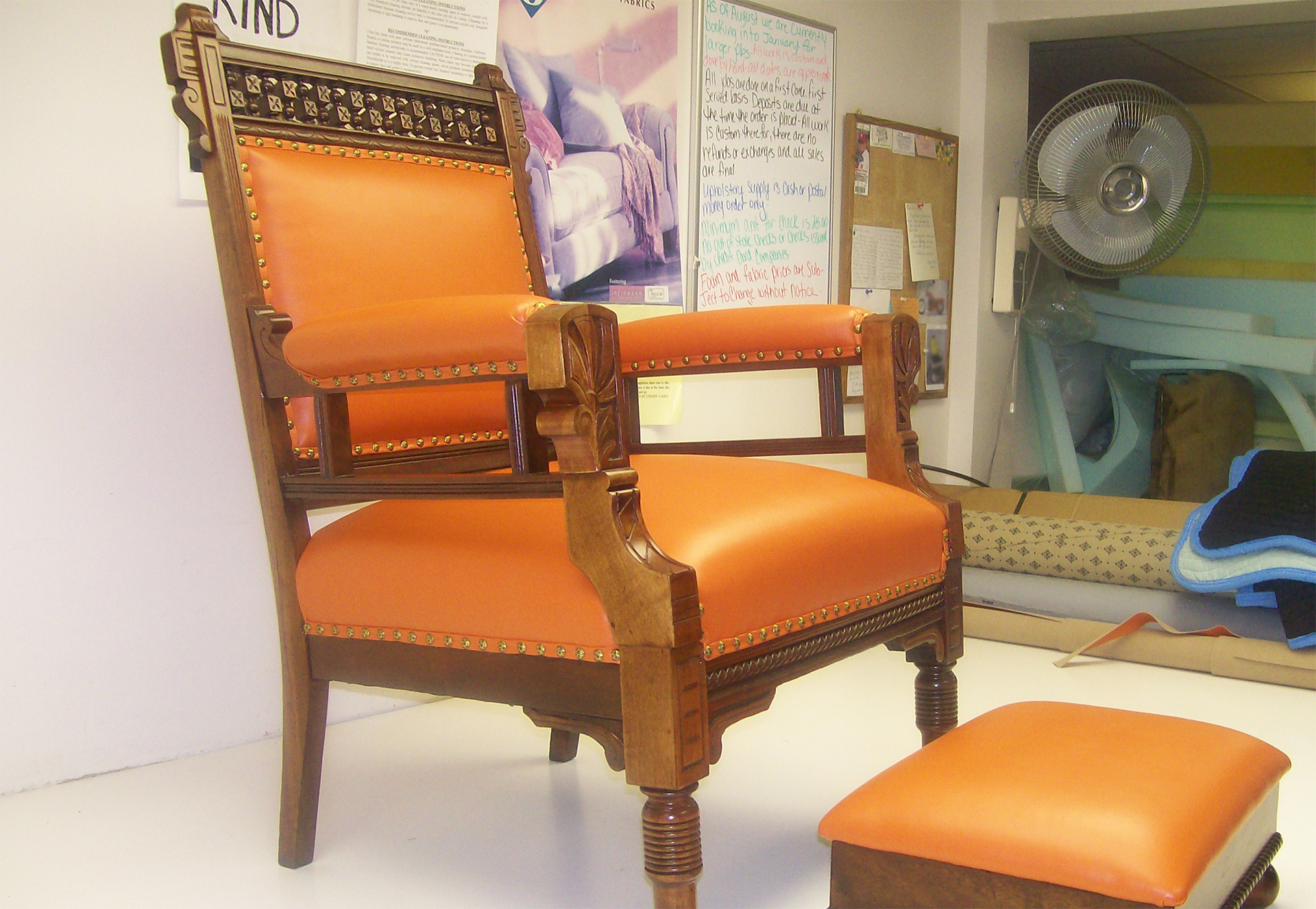 An orange chair and ottoman in a room with a sign that says kind