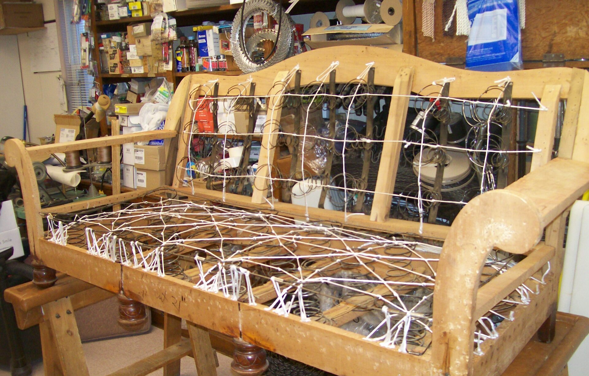 A wooden couch is being built in a workshop