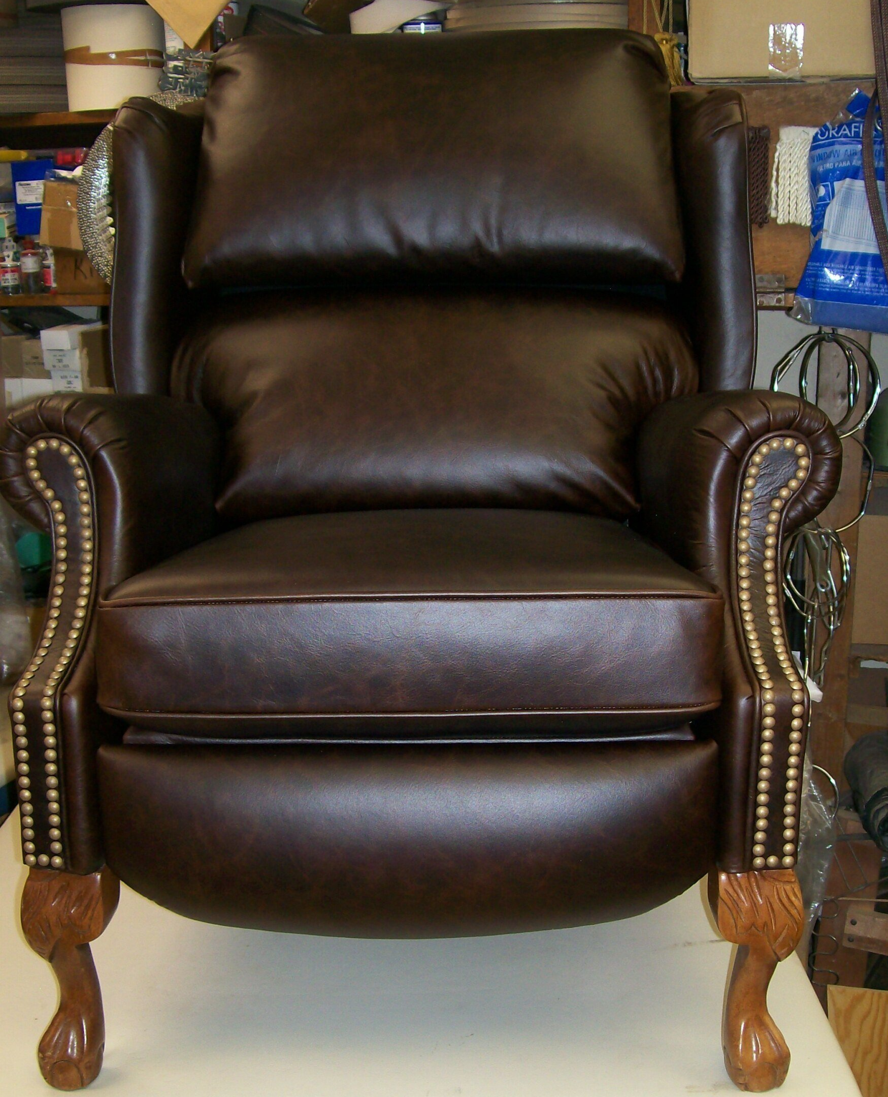 A brown leather chair is sitting on a white table
