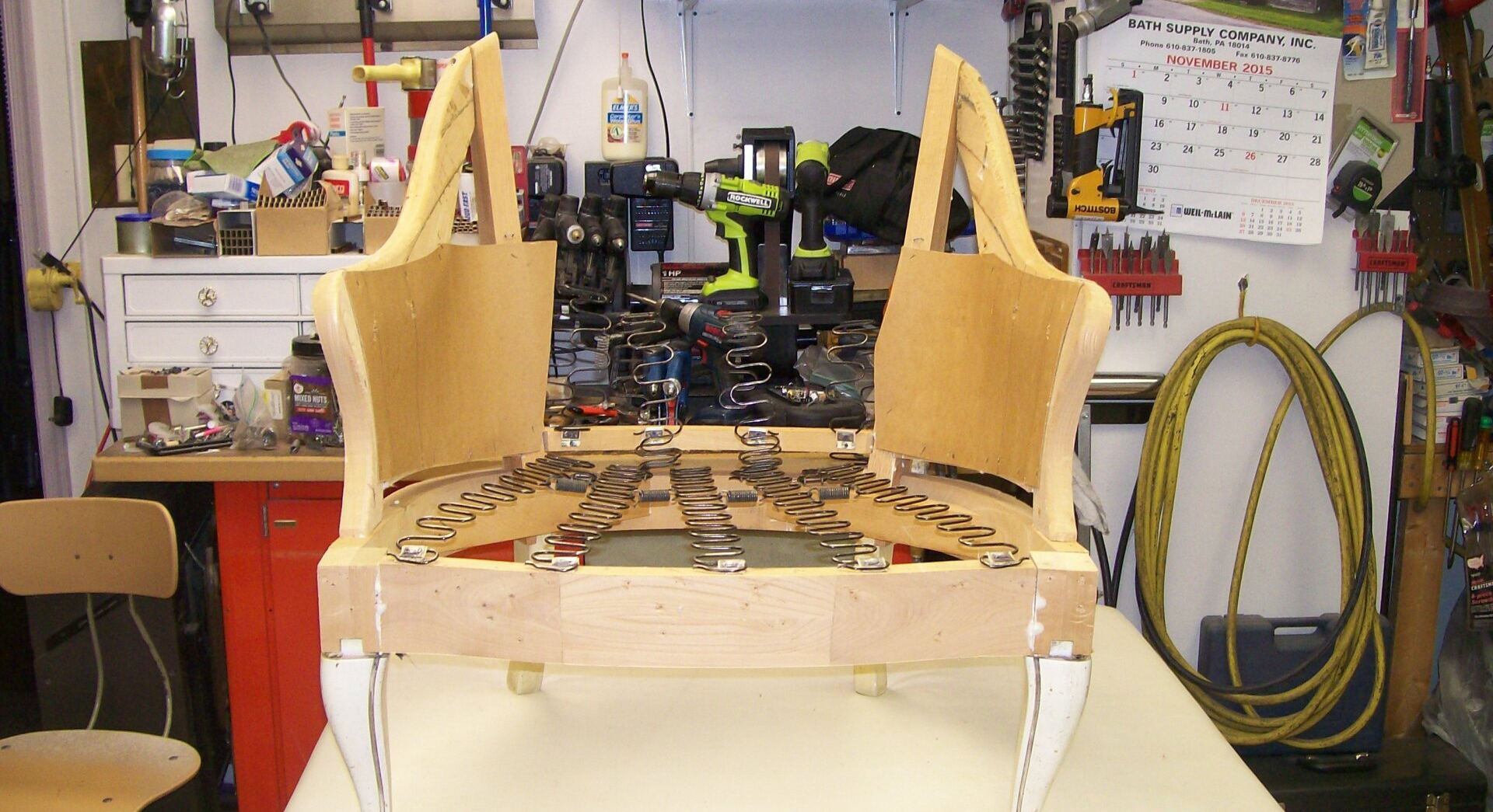 A wooden chair is sitting on a table in a workshop.