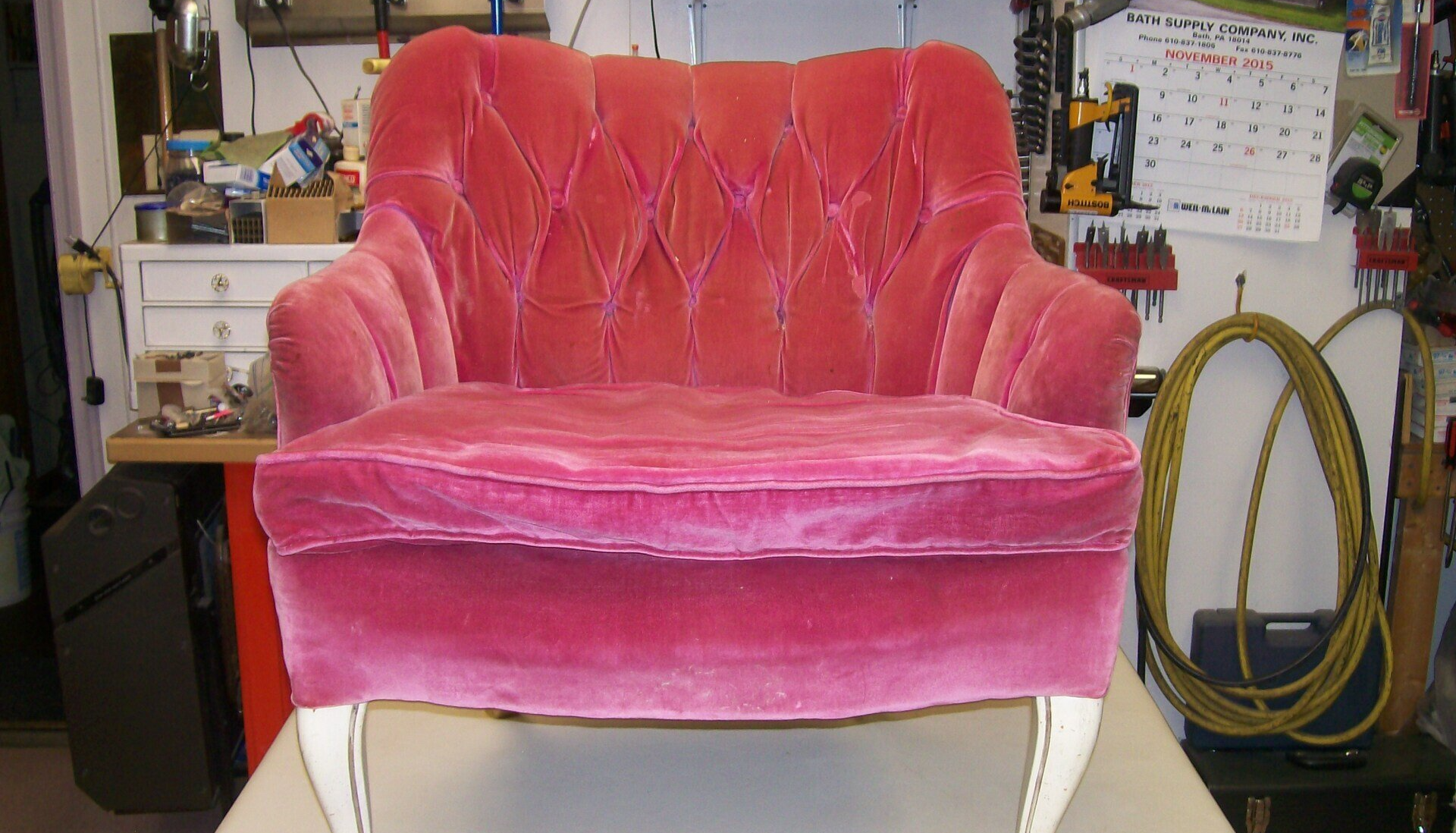 A pink chair is sitting on a white table in a room.