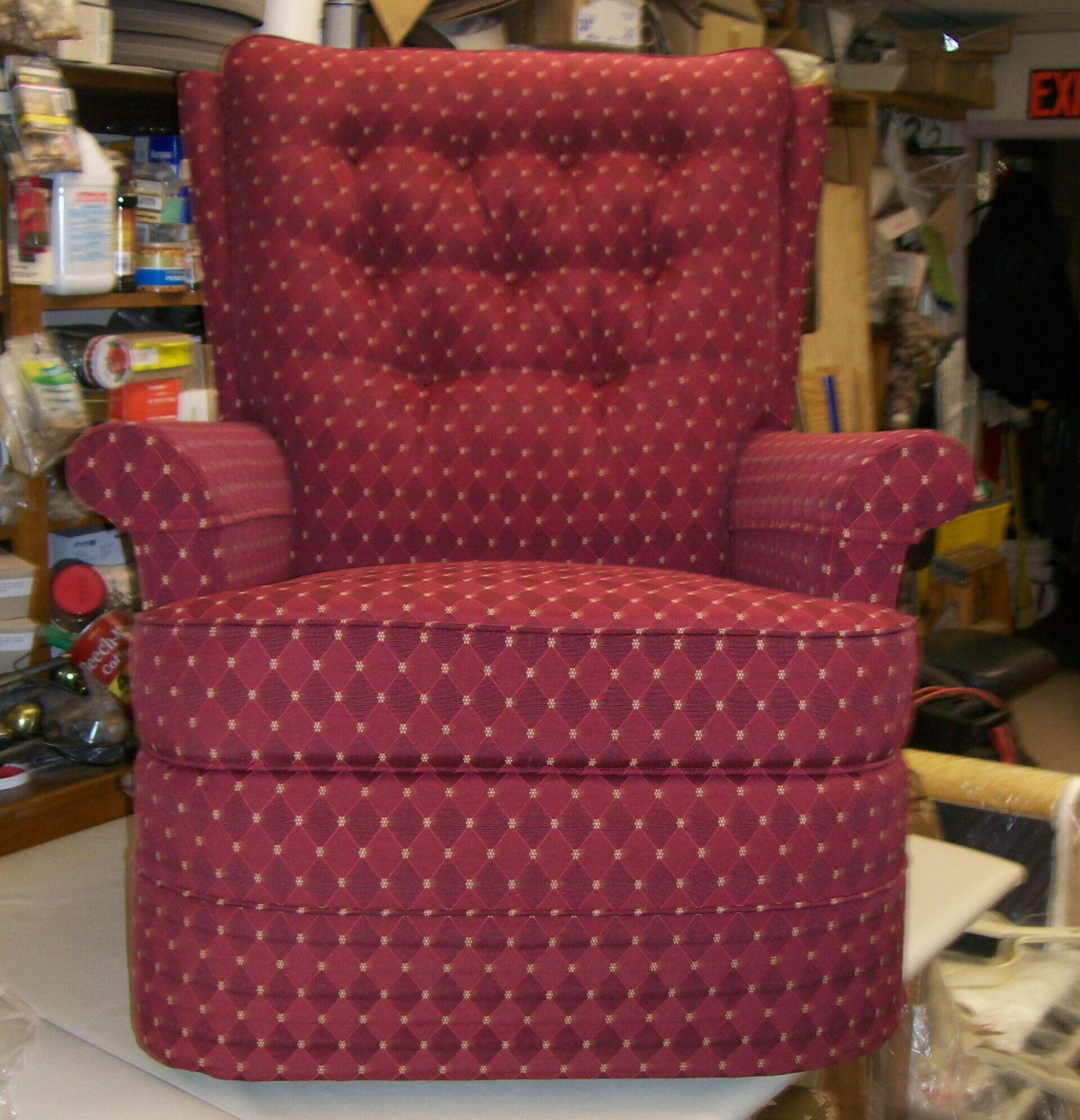 A red chair with white polka dots sits in front of an exit sign