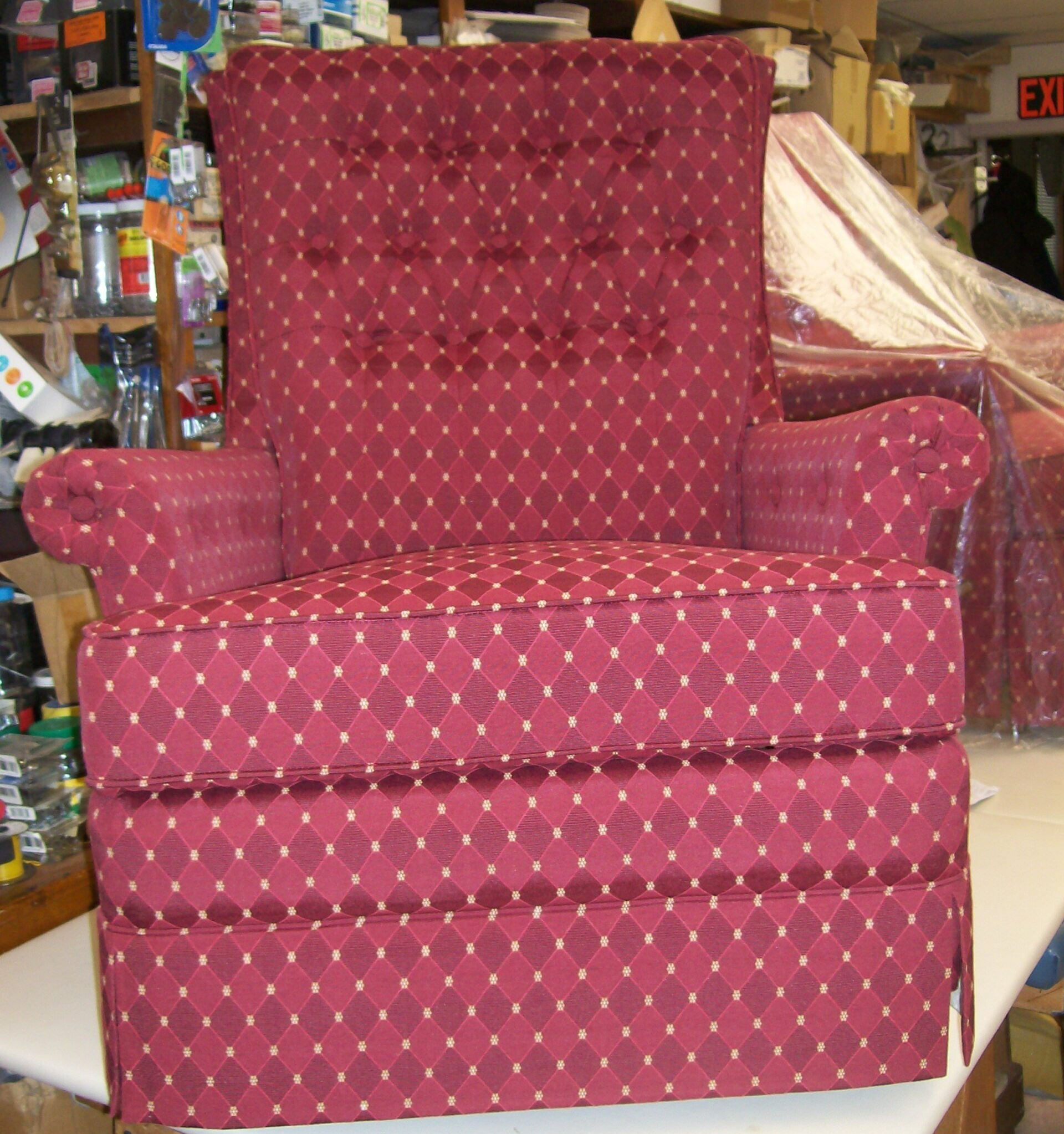 A red chair is sitting on a table in front of an exit sign