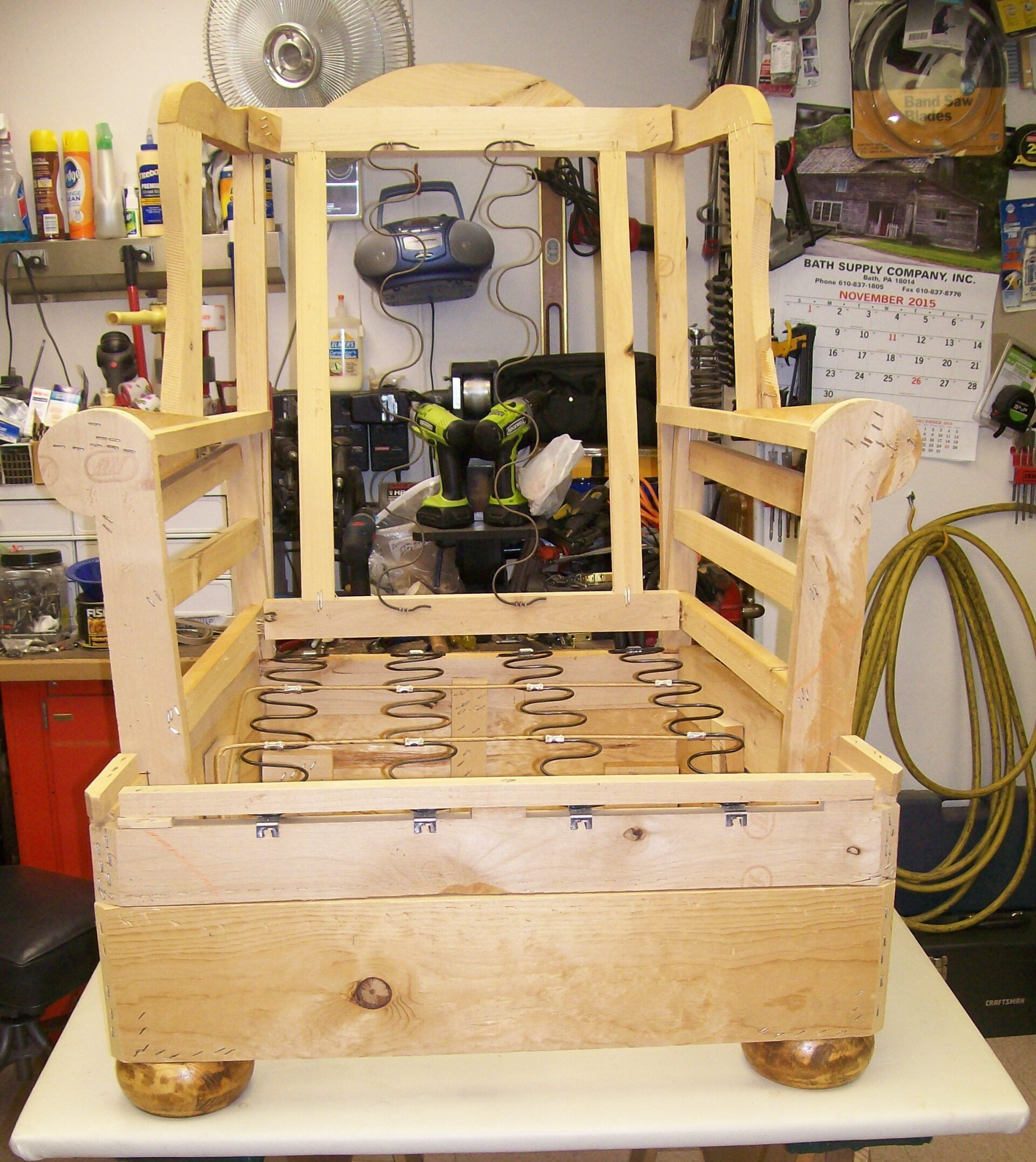 A wooden chair frame is sitting on a table in a workshop
