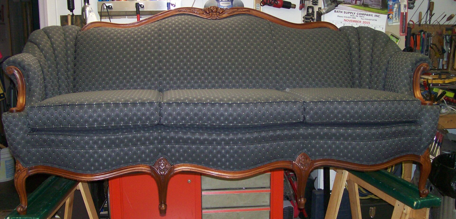 A couch with a wooden frame is sitting in a room