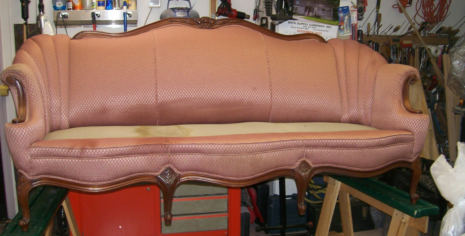 A pink couch is sitting on top of a red table