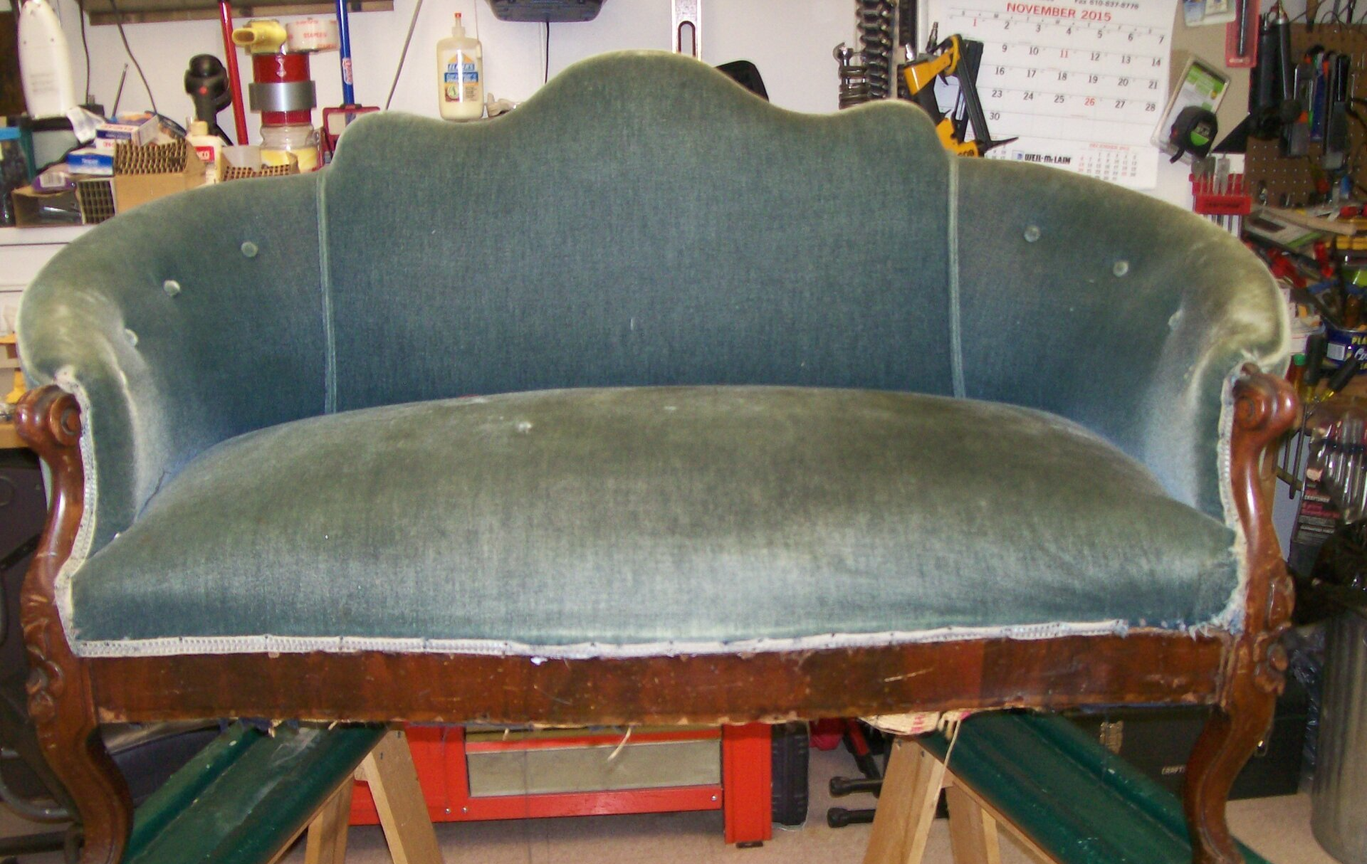 A green couch is sitting on a wooden table