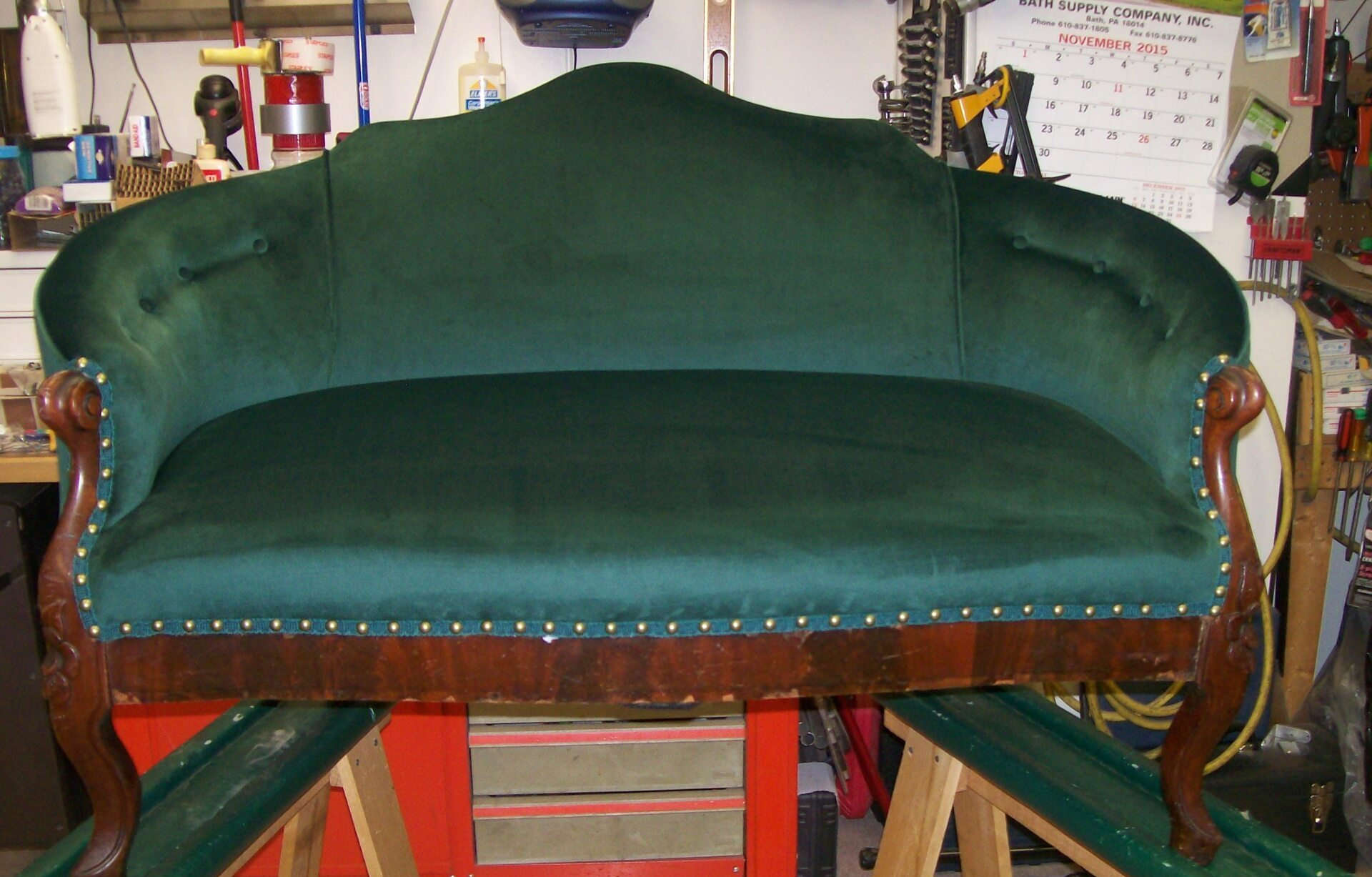 A green couch is sitting on a wooden table