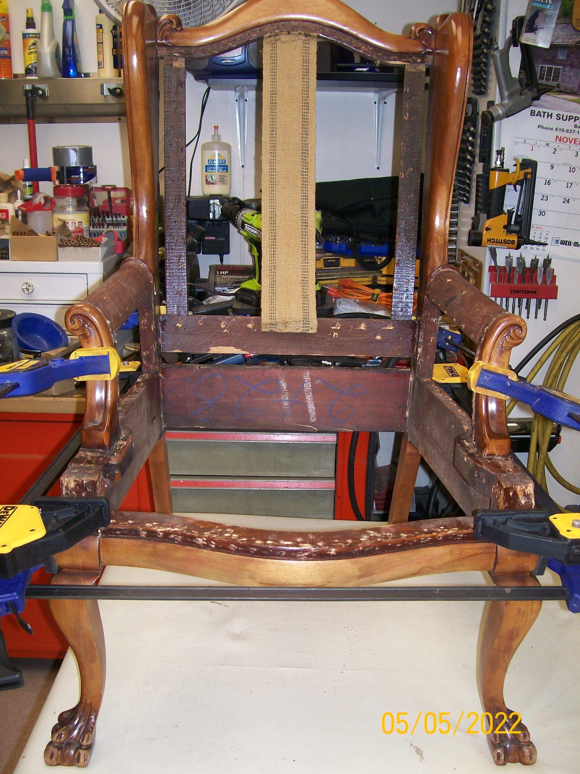 A wooden chair is being repaired in a garage