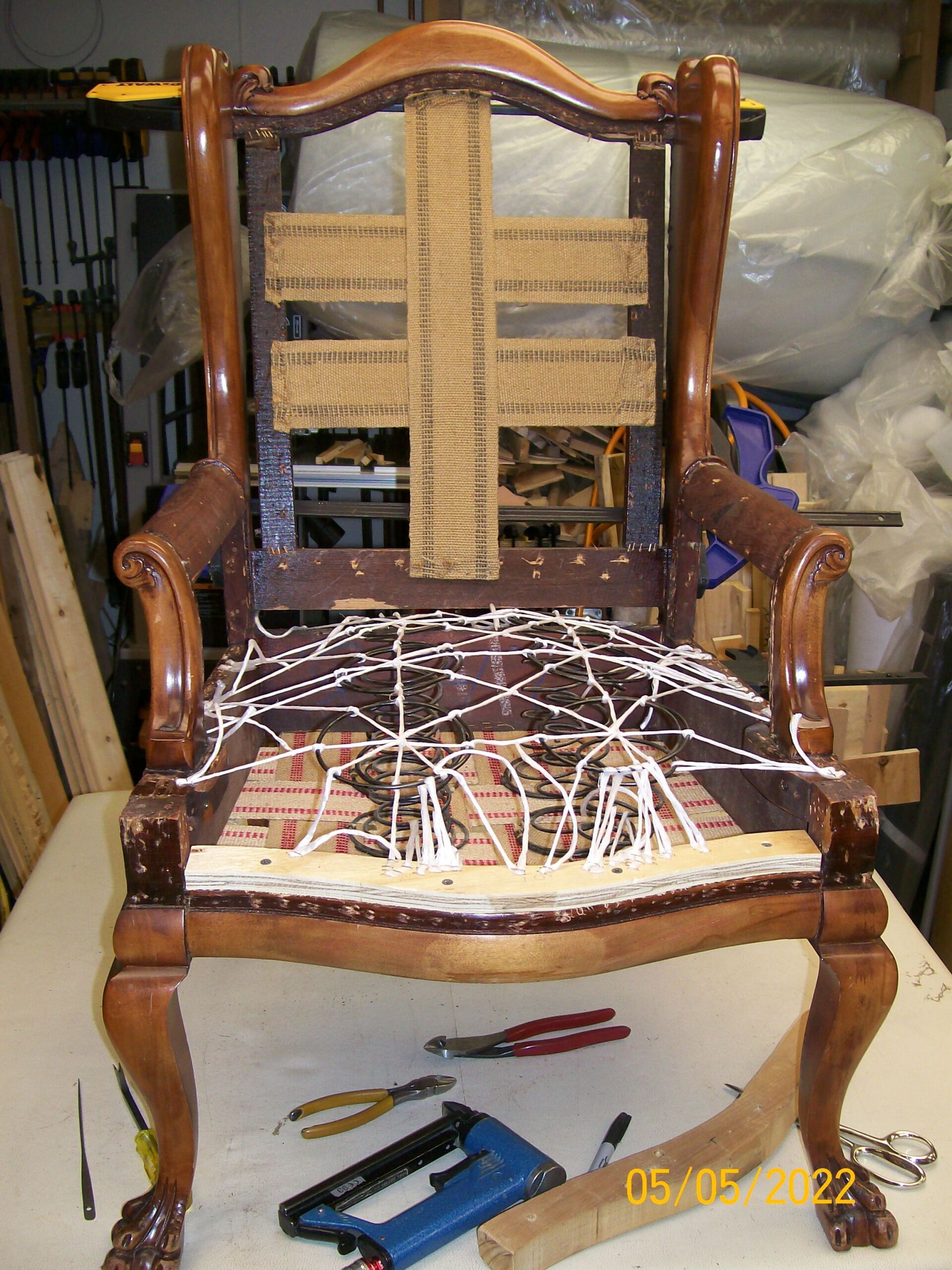 A chair is sitting on a table with tools on it