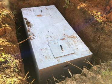 A large concrete box is sitting in the dirt