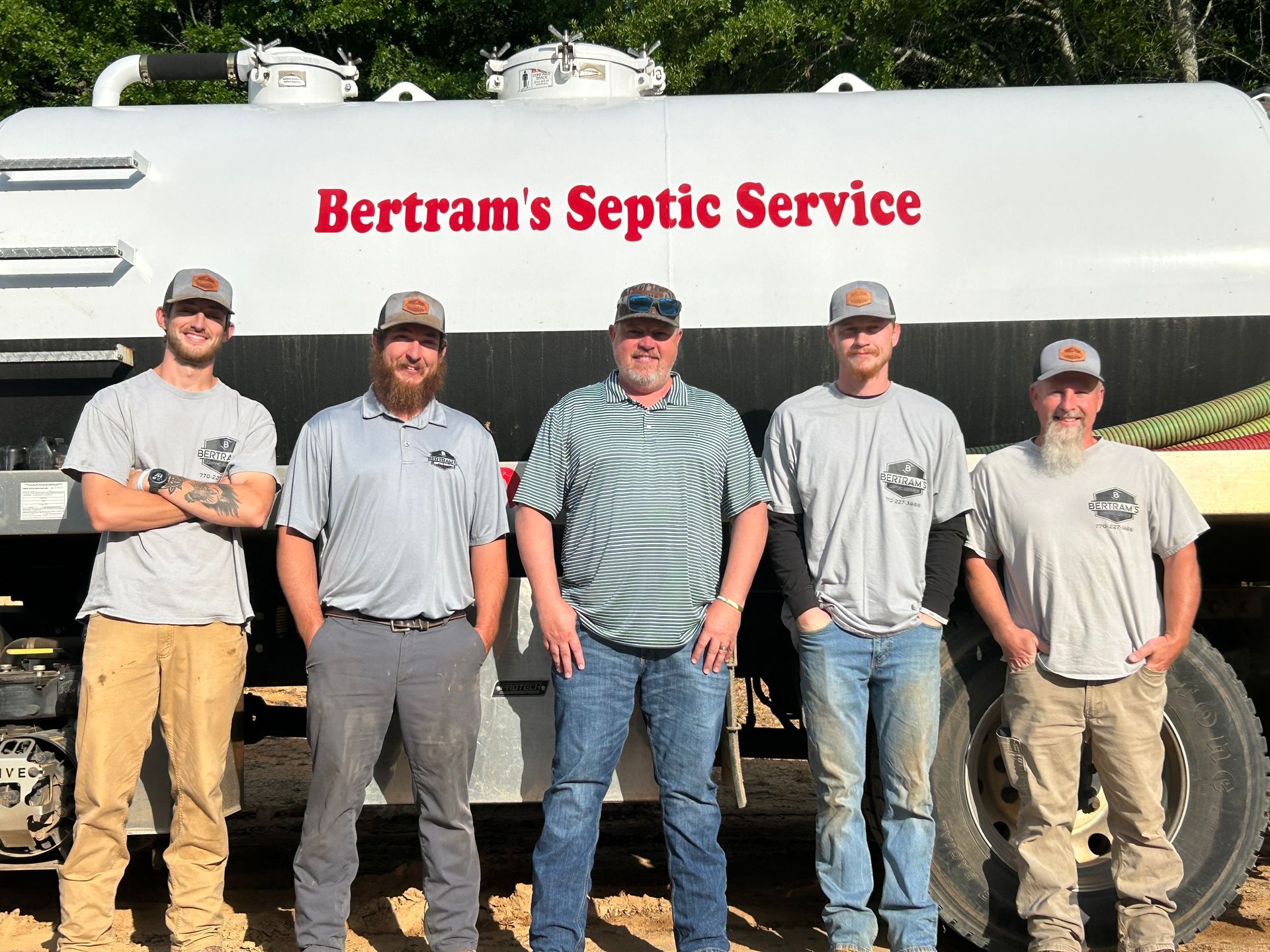 A group of men standing in front of a septic service truck