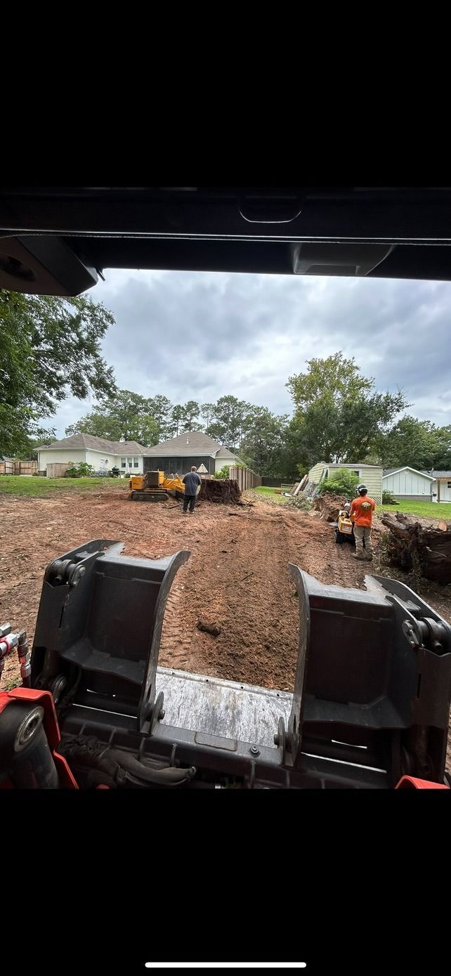 A person is driving a bulldozer through a dirt field.