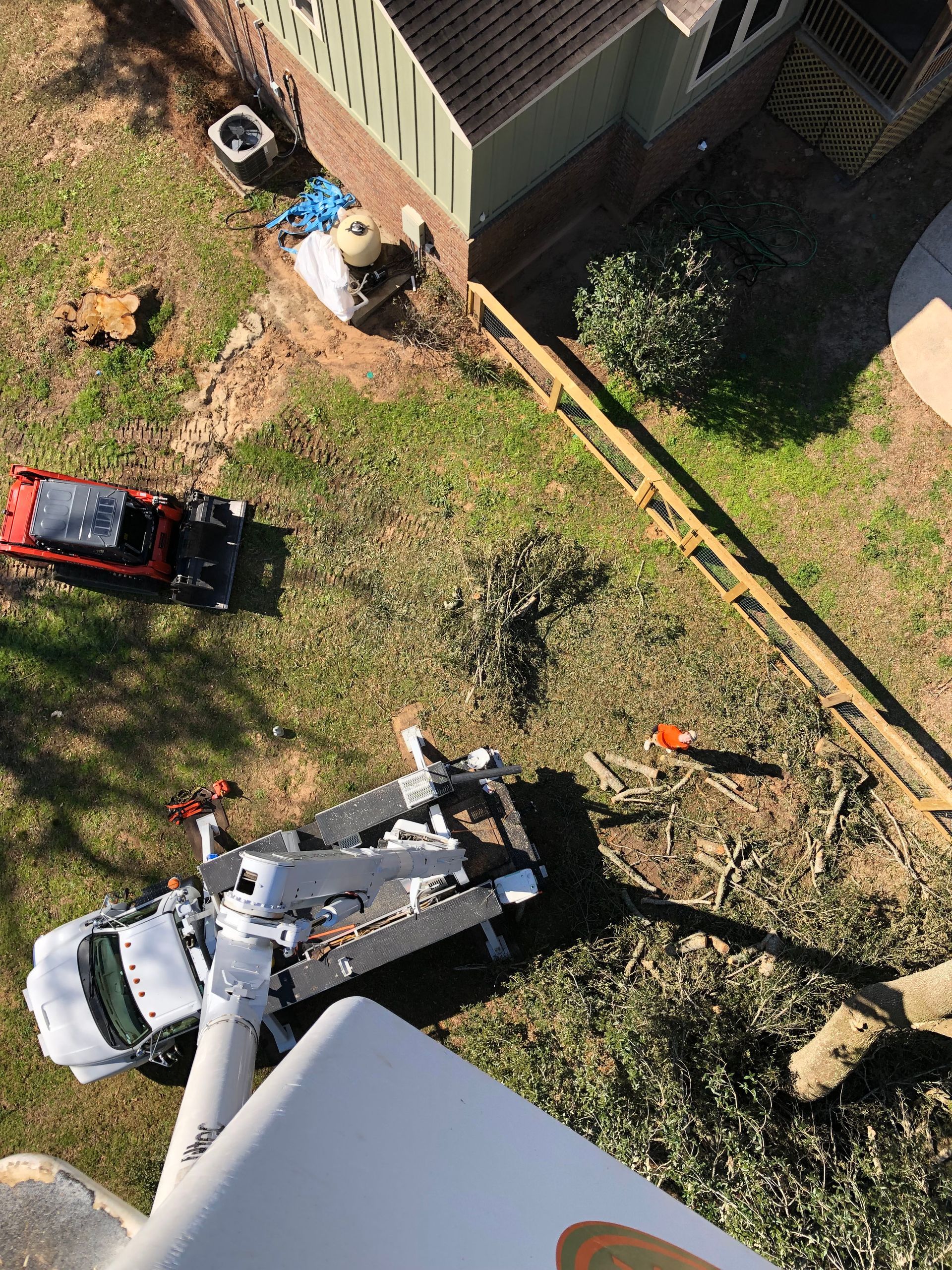 An aerial view of a tree cutting truck in a yard.