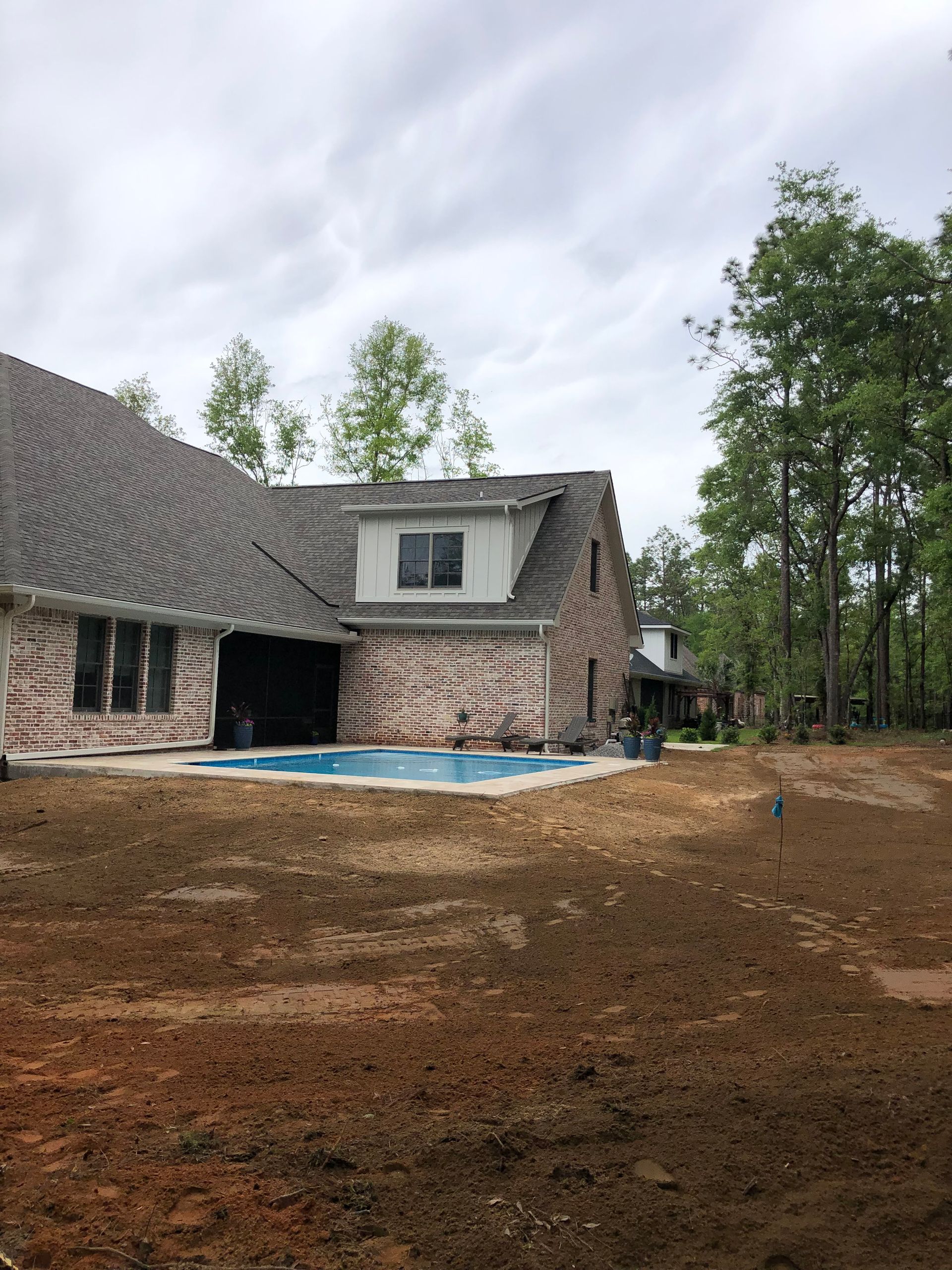 A brick house with a swimming pool in the backyard.