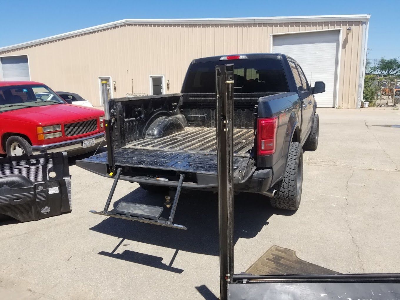 A truck with a ladder in the back is parked in front of a building