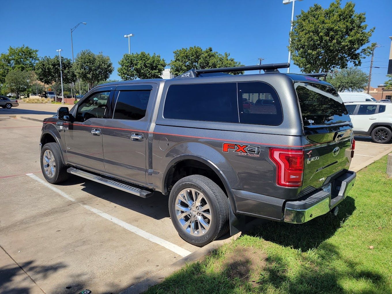 A gray ford f150 is parked in a parking lot.