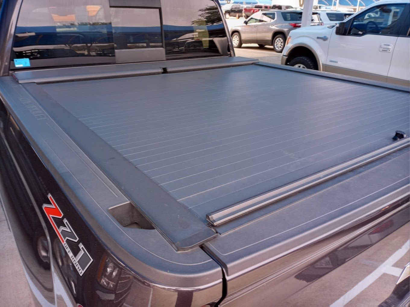 A gray truck with a roll up bed cover on it